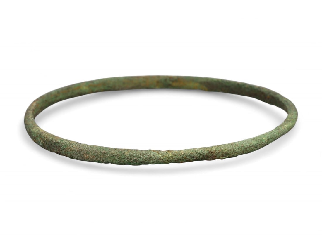 Ancient Roman Delicate Bronze Ritual Bracelet, c. 1st-3rd Century CE: This graceful and understated Ancient Roman bronze bracelet, dating to the 1st-3rd century CE, embodies the elegance of classical simplicity. Measuring 6.6 cm (2.6 in) in diameter, its slender, contin