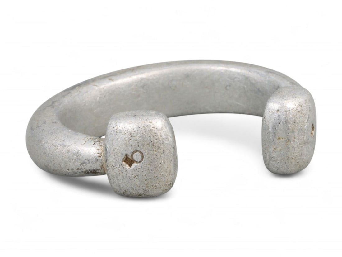 Post-Medieval West African Cast Aluminum Bracelet with Punched Terminal Mark, c. 18th-19th Century: This cast aluminum bracelet from West Africa, dated to the 18th-19th century CE, is a fine example of tribal metallurgy fused with symbolic minimalism. Measuring 6.8 cm (2.68 in) in diameter and weigh