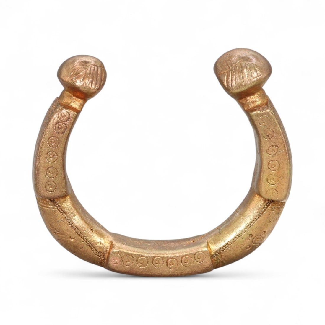Ancient West African Gilt Bronze Manila Bracelet with Sunburst Terminals, c. 15th-17th Century CE: This striking West African manilla bracelet, measuring 7.8 cm (3.07 inches) in diameter, exemplifies the synthesis of artistry and currency that defined early contact-period trade in West Africa. Fash