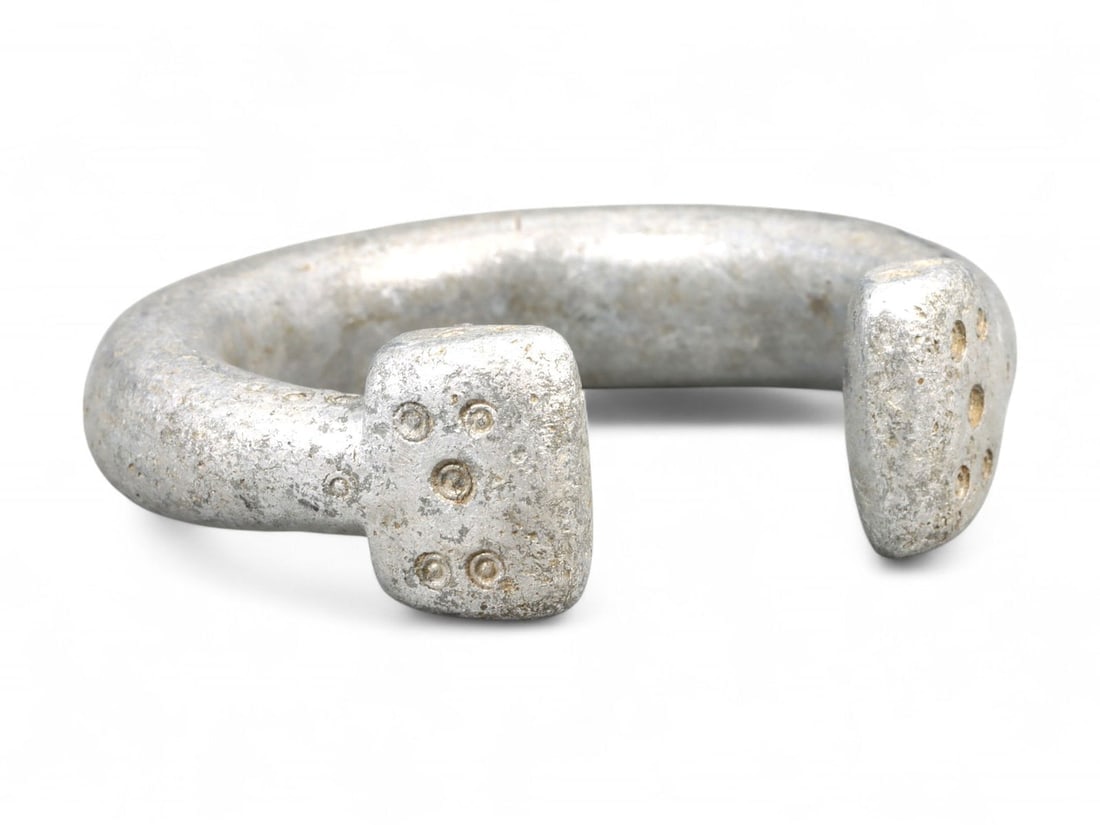 Antique West African Cast Aluminum Trade Bracelet, c. 18th-19th Century CE: This substantial cast aluminum bracelet from West Africa dates to the 18th-19th century CE and was likely used both as adornment and as a form of trade currency. Measuring 7 cm, the bracelet is define