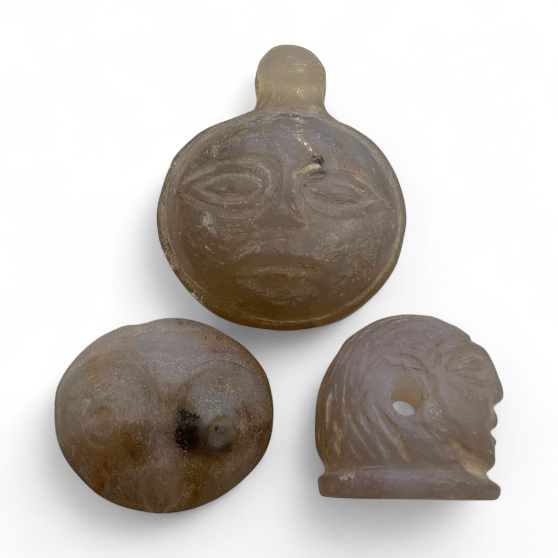 Ancient Sasanian Chalcedony Anthropomorphic Amulet Trio, c. 3rd-6th Century CE, 55g: This expressive trio of carved chalcedony amulets from the Sasanian Empire, dating to the 3rd-6th century CE, embodies the artistic and symbolic richness of late antique Persia. Sculpted in translucen