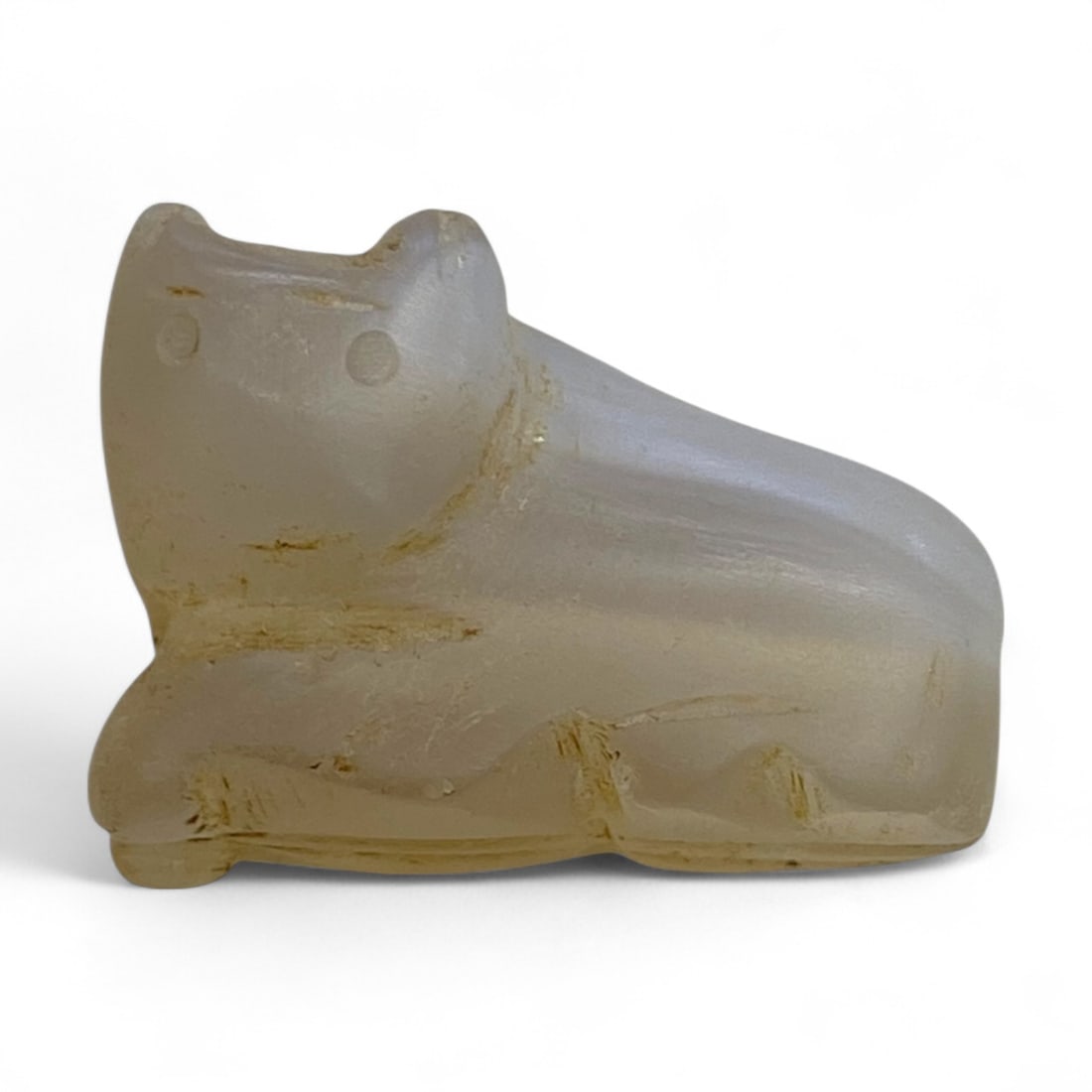 Ancient Near Eastern Reclining Feline Chalcedony Amulet, c. 1st Millennium BCE, 12g, 3cm: This delicately carved feline amulet, sculpted from translucent chalcedony, embodies the spiritual and artistic essence of ancient Near Eastern talismanic culture. Weighing just 12g and measuring 3 cm