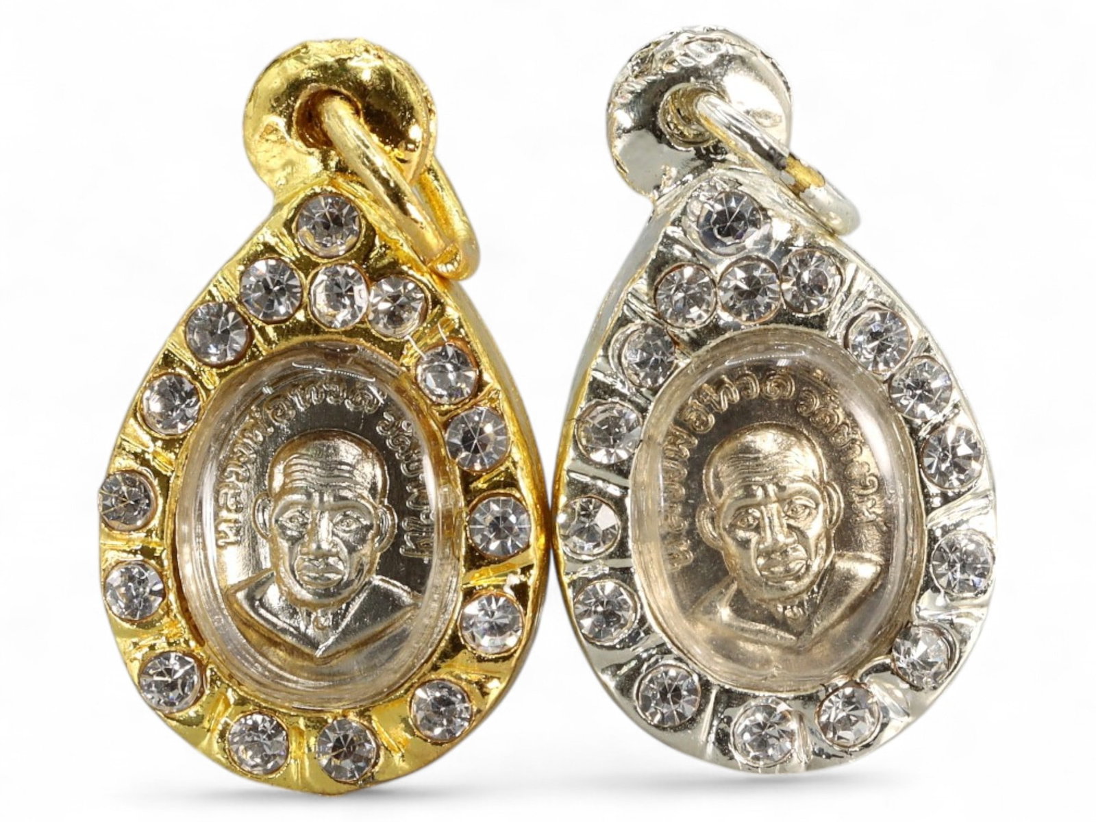 Thai Luang Phor Thuad Amulet Pair with Faux Gemstone Frames, c. Late 20th Century, 29g: This vibrant pair of miniature Thai amulets features the revered image of Luang Phor Thuad, a legendary Buddhist monk known for his miracles and spiritual prowess. Encased in dazzling, faux-gemstone-s