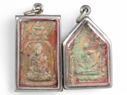 Thai Clay Amulet Pair with Faded Polychrome Reliefs, c. Mid-Late 20th Century, 48g: This evocative pair of Thai amulets, encased in protective silver-toned metal frames, reflects the enduring spiritual artistry of mid-20th-century Thailand. Each amulet, measuring approximately 5-6 cm