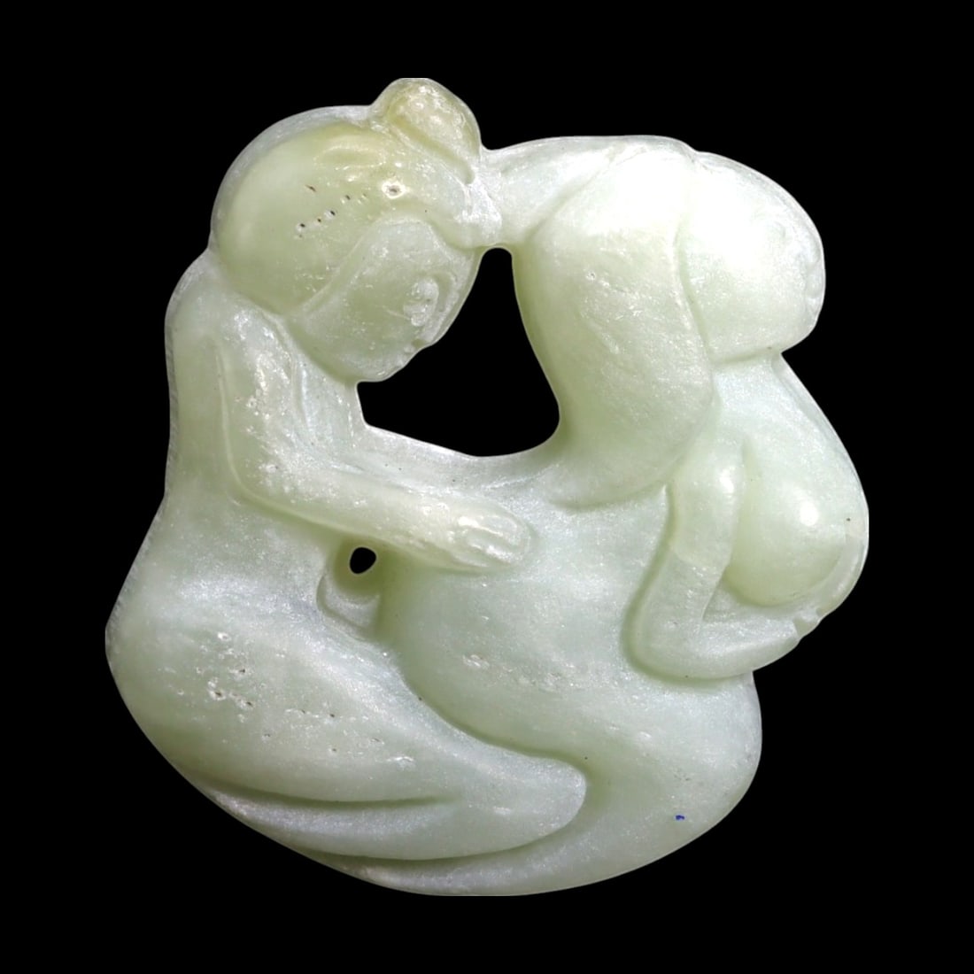 Antique Chinese Erotic Intimacy Motif Nephrite Jade Amulet, 51g: This Antique Chinese nephrite jade amulet presents a candid and expressive scene of a couple in intimate embrace, captured with fluid lines and soft contours in pale green jade. The composition is bal