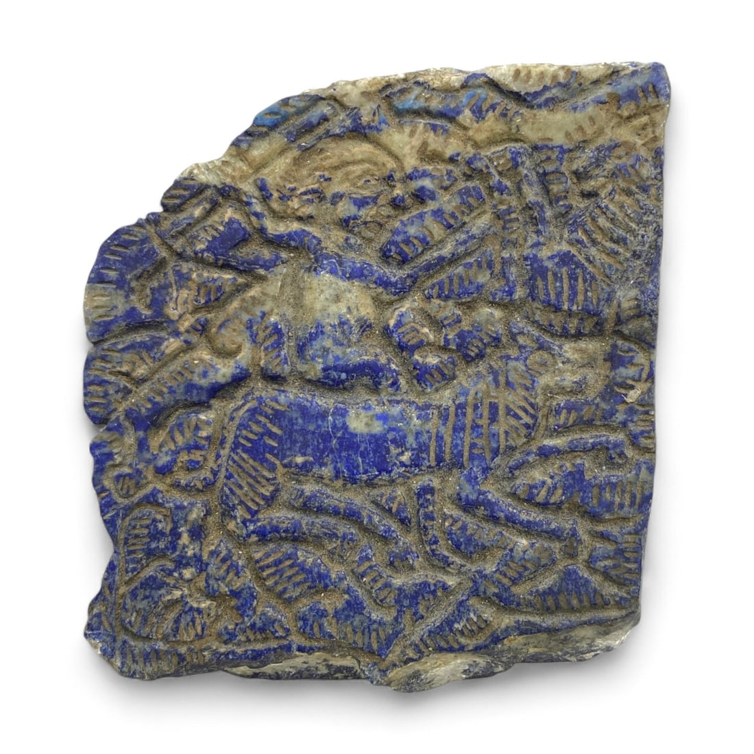 Ancient Near Eastern Mythic Animal Relief in Lapis Lazuli, c. 2nd Millennium BCE, 15 cm, 1376g: This magnificent relief fragment, carved from dense lapis lazuli and weighing an impressive 1376 grams (48.5 oz), captures the visual splendor and symbolic power of ancient Near Eastern art. Measuring