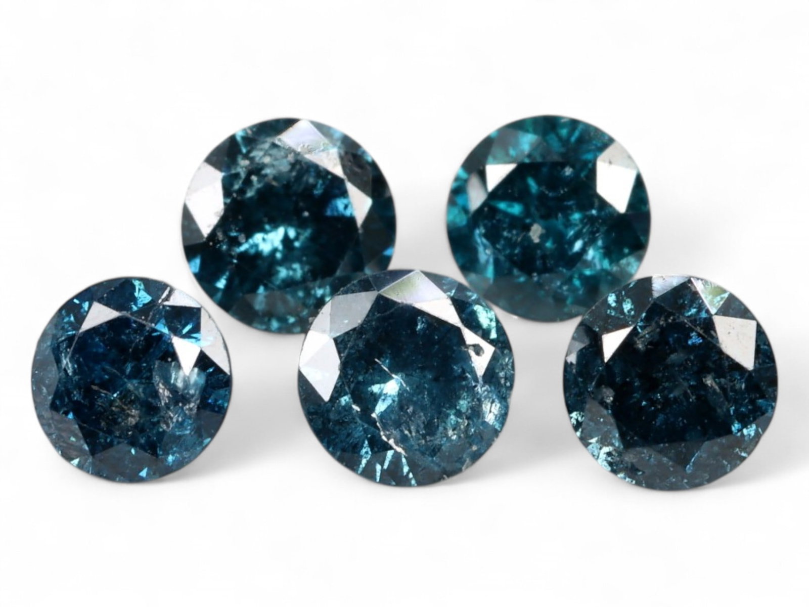 0.45ct Natural FANCY BLUE Diamond Lot - Round Cut, Irradiated, 2.8 mm each: This vibrant 0.45-carat parcel of round-cut diamonds features a dramatic range of deep oceanic blues, achieved through irradiation to intensify their natural brilliance. Each stone measures approximat