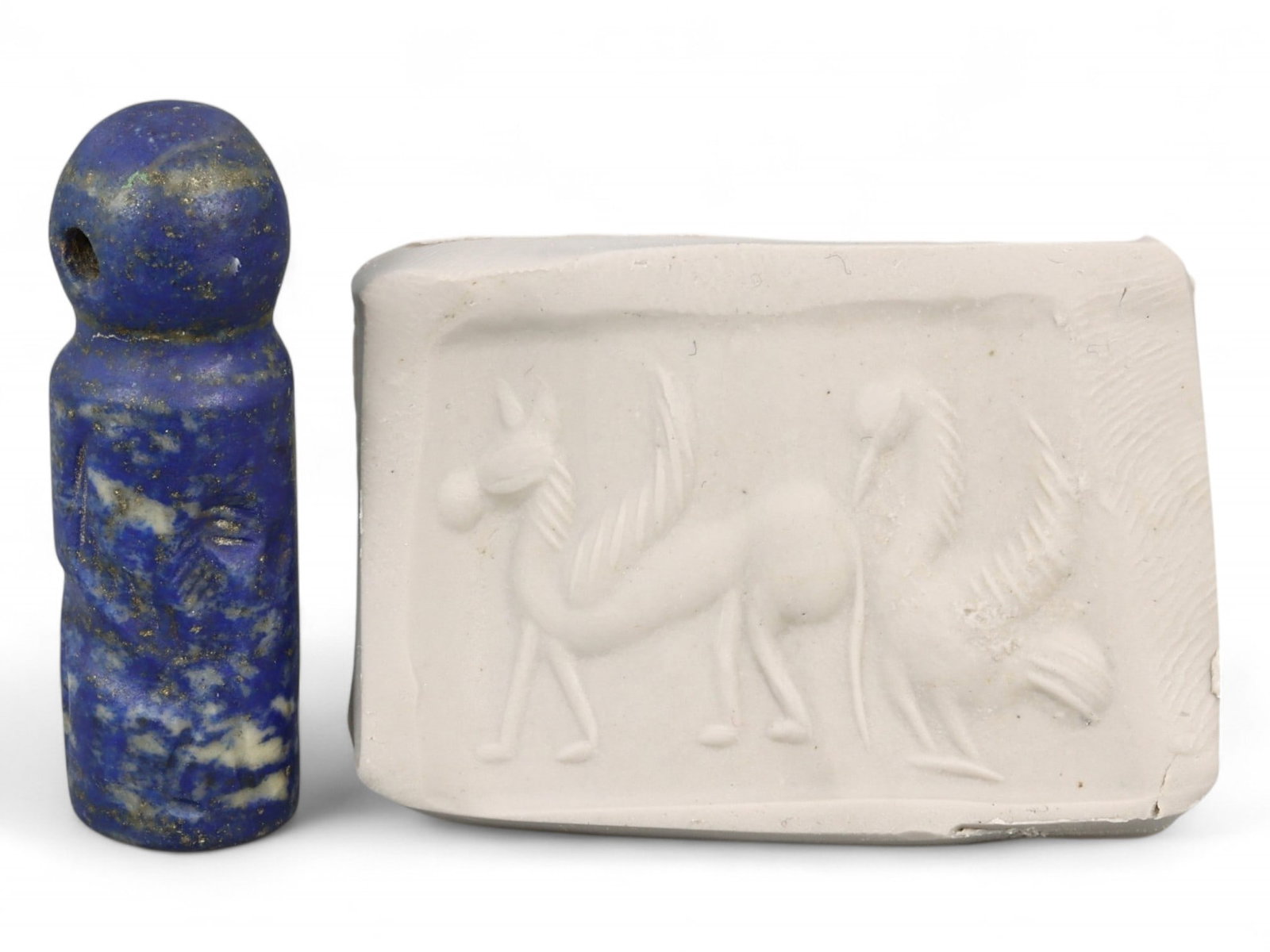 Ancient Akkadian Winged Griffin and Equine Cylinder Seal in Lapis Lazuli, 23rd-22nd Century BCE, 8g: This exquisite cylinder seal, carved from radiant lapis lazuli, hails from the Akkadian Empire, a seminal force in early Mesopotamian civilization. The motif depicts a stylized equine figure alongside