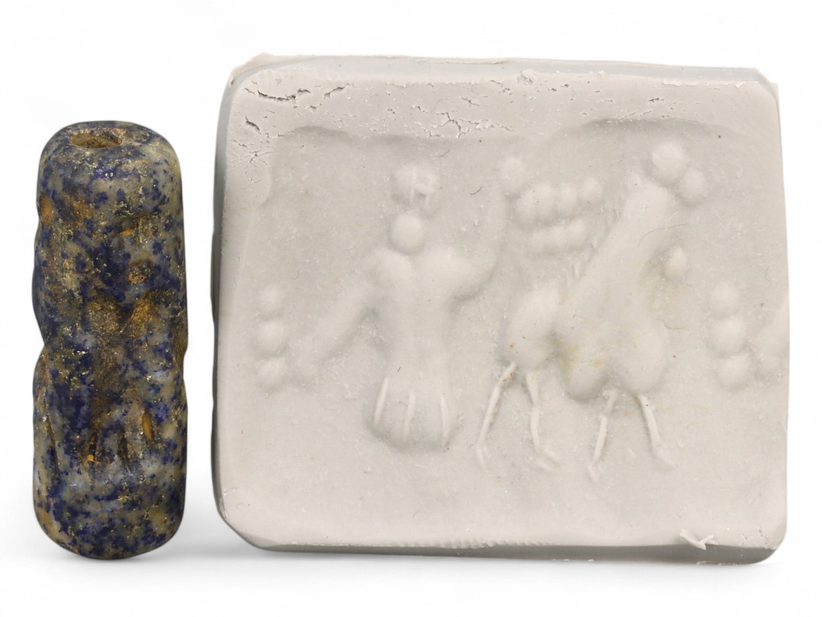 Ancient Akkadian Worshipper and Ibex Cylinder Seal in Lapis Lazuli, c. 23rd-22nd Century BCE, 5g: This compact yet evocative cylinder seal carved in rich lapis lazuli originates from the Akkadian Empire, dating to the 23rd-22nd century BCE. The seal's impression features a standing figure in a wor