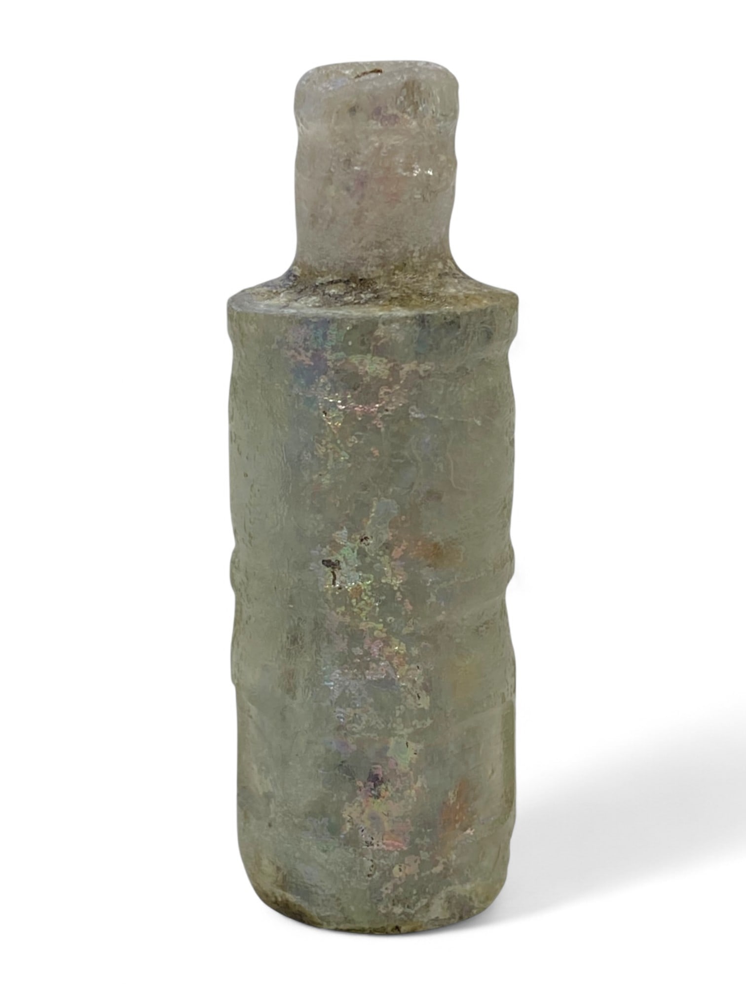 Ancient Roman Iridescent Glass Cosmetic Flask, c. 1st-3rd Century CE: This slender Roman glass flask, dating to the 1st-3rd century CE, is a graceful example of ancient utilitarian artistry. Standing 6 cm tall and weighing 22 grams, its cylindrical form and narrow neck