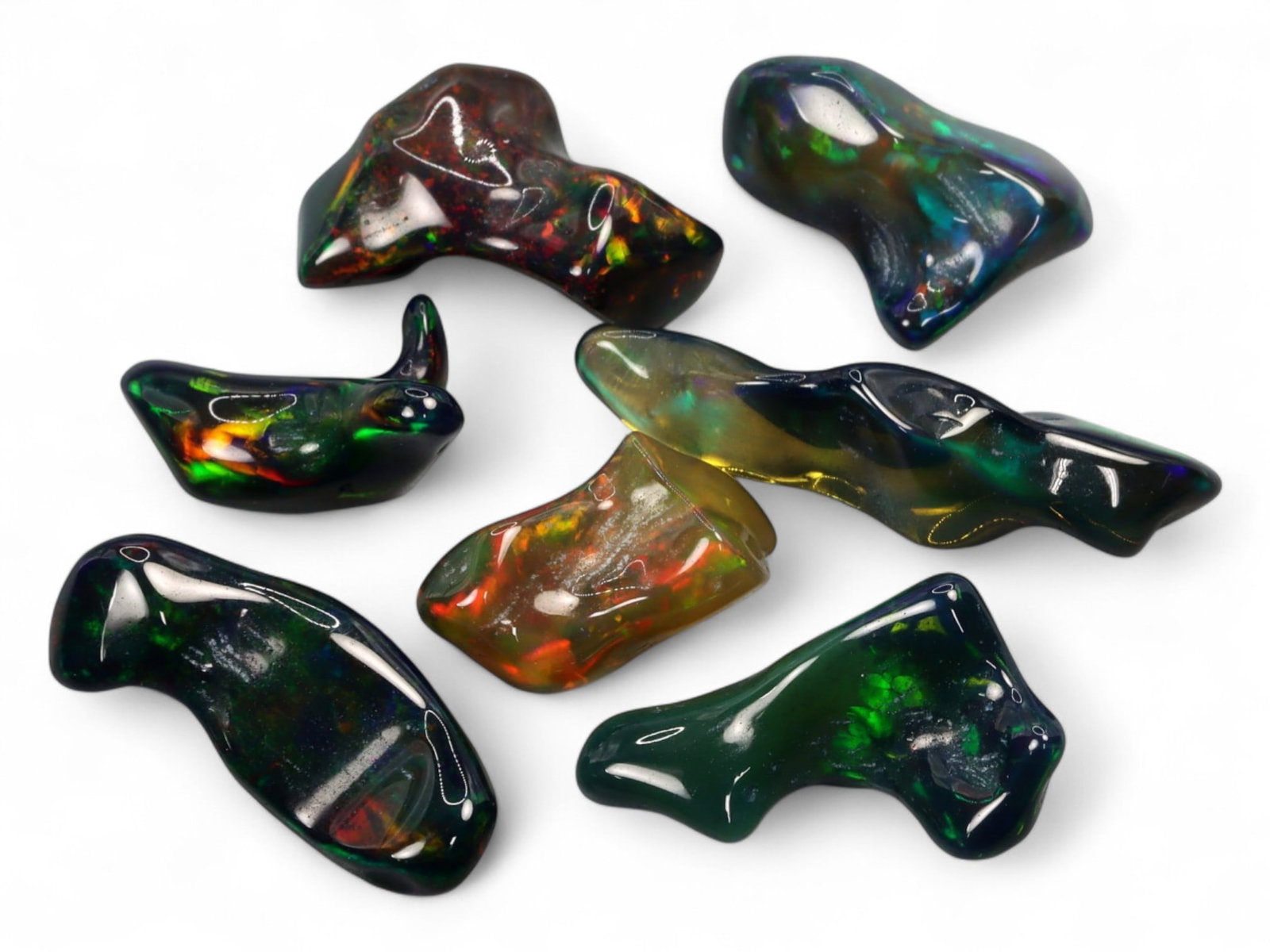 18.05ct Natural Ethiopian Black Smoked Opal Parcel Lot: A striking parcel of polished rough Ethiopian black smoked opals, this selection showcases freeform organic silhouettes with intense, multi-directional play-of-color. Each piece gleams with a glossy f