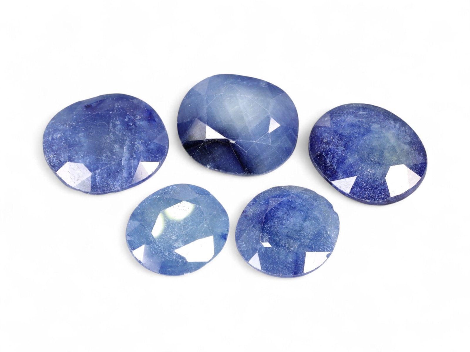 45.29 Carats Velvet Blue Sapphire Parcel - Natural Sri Lankan Stones: This elegant parcel of faceted sapphires showcases a velvety range of cool blue tones, from slate and twilight to soft cornflower hues. Each stone is fashioned in a gently domed oval cut, emphasizing 