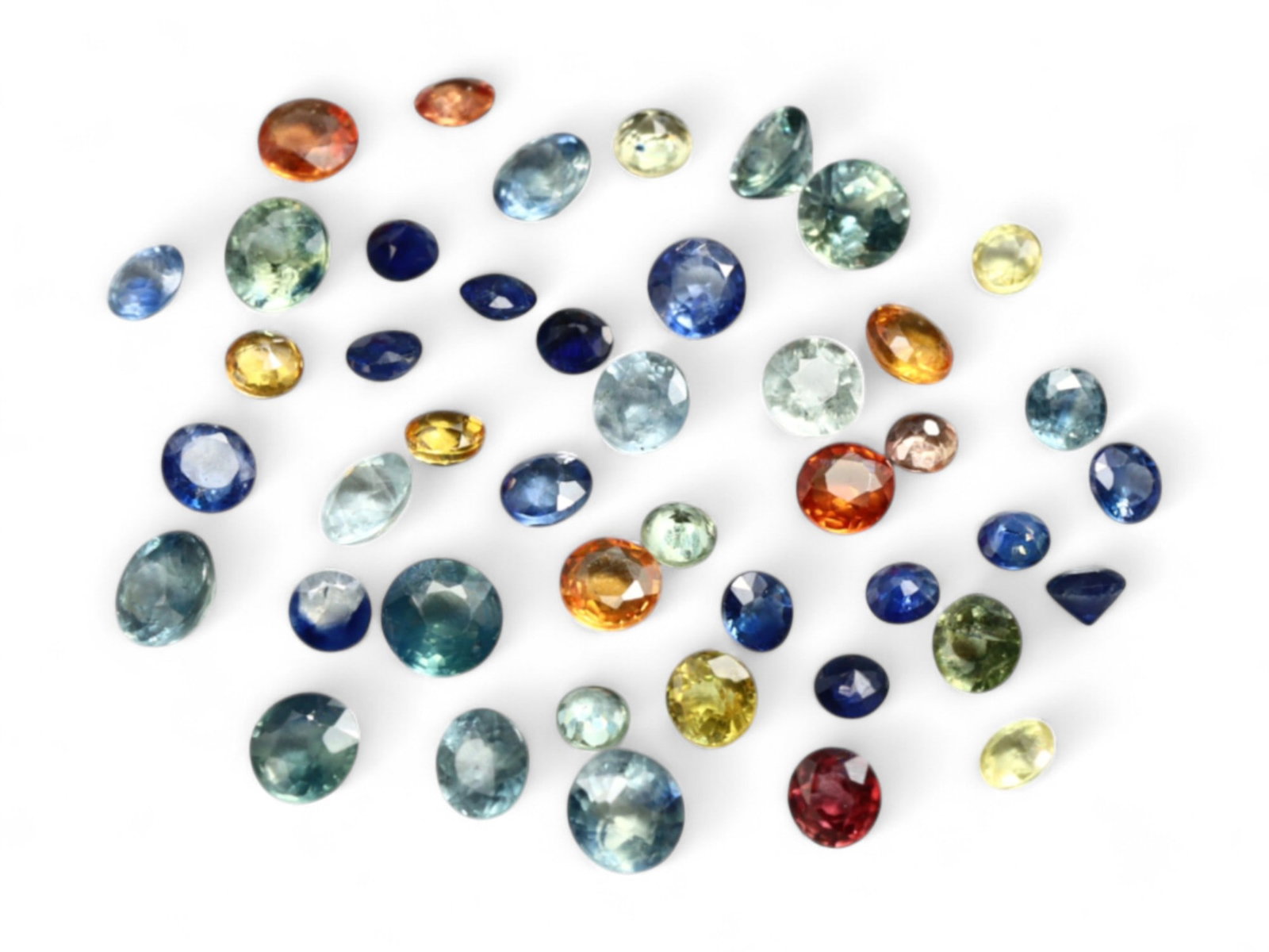 8.30 Carats Multicolor Fancy Sapphire Selection - Natural Mixed Origins: A brilliant array of color and sparkle, this 6.75 carat lot of round and oval-cut fancy sapphires delivers a joyful celebration of hue diversity. From vibrant yellows and deep royal blues to soft gree