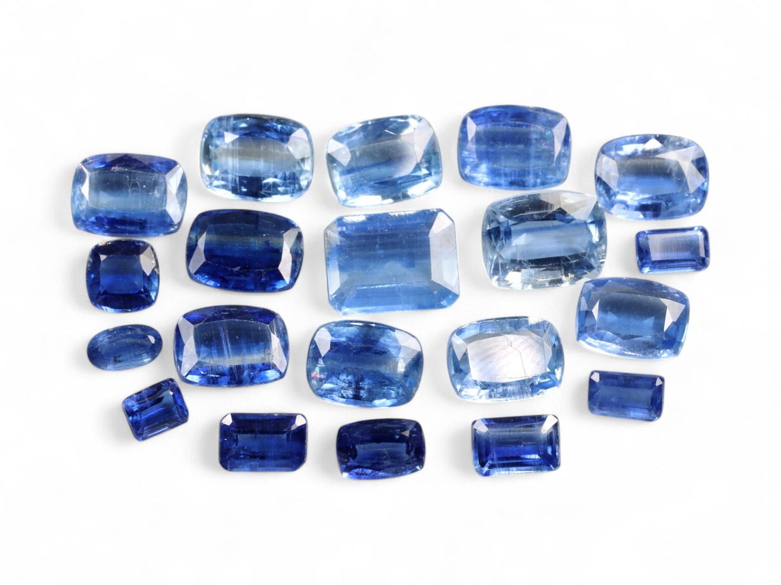 25.20 Carats Mixed Blue Kyanite Selection - Natural Nepalese Stones: This captivating selection of kyanite gemstones displays a shimmering spectrum of deep royal to icy sky blues, unified by their crystalline luster and vitreous transparency. Cut in an array of cushion