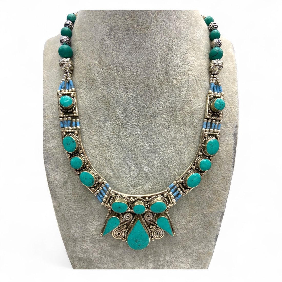 Tibetan Ornamental Turquoise and Silver Alloy Festival Necklace, 127g: This ornate Tibetan necklace embodies the bold spirit and sacred artistry of Himalayan culture, weighing a substantial 127 grams. At its heart lies an elaborate design of bezel-set turquoise cabochons