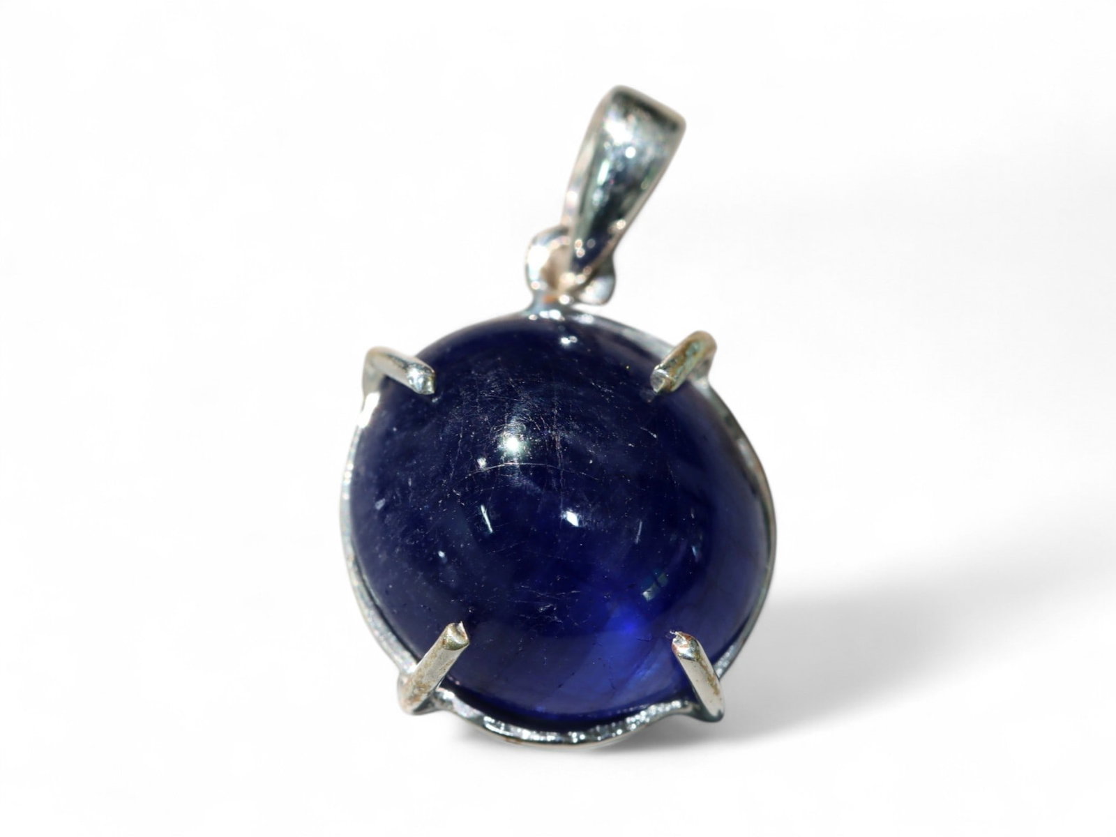 Blue Sapphire Cabochon Pendant in Sterling Silver - 2.18 Grams: This elegant pendant features a deep blue sapphire cabochon set in polished sterling silver, creating a timeless combination of regal color and classic form. The sapphire's rich, inky tone is accented