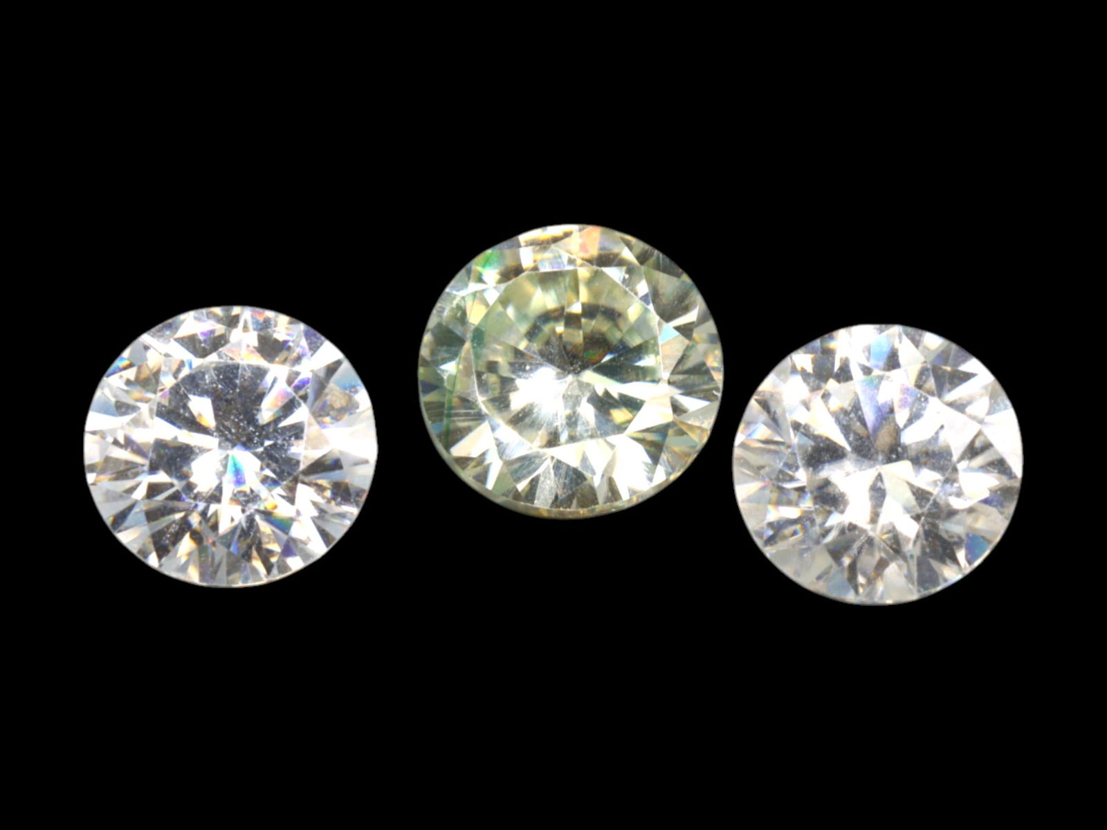 4.72 Carats Round Brilliant Moissanite Lot - Natural-Look Near-Colorless Stones: This radiant group of three round brilliant moissanite gems bursts with fire and clarity, capturing the hallmarks of fine cutting and modern brilliance. Each stone showcases a crisp, near-colorless bo