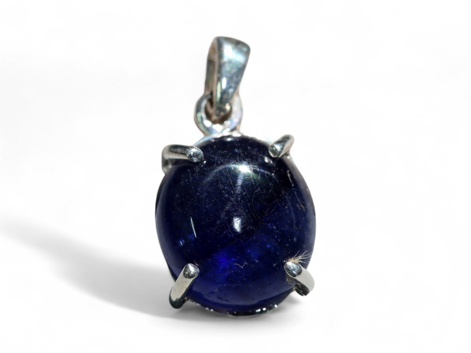 Blue Sapphire Cabochon Pendant in Sterling Silver - 2.34 Grams: This elegant pendant features a deep blue sapphire cabochon set in polished sterling silver, creating a timeless combination of regal color and classic form. The sapphire's rich, inky tone is accented