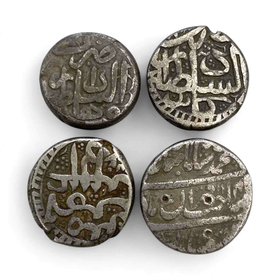 Medieval Islamic Sultanate Silver Coinage Group, c. 14th-18th Century CE, 40g: This distinguished group of four silver coins, each approximately 2 cm in diameter and together weighing 40 grams (1.4 oz), represents the refined monetary traditions of various Islamic sultanates and