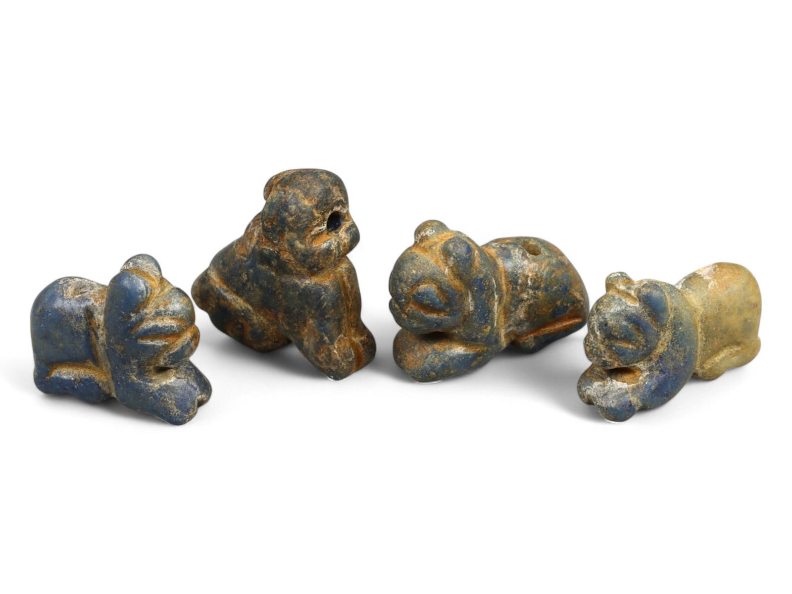 Ancient Bactrian Reclining Animal Lapis Lazuli Amulets, c. 3rd-2nd Millennium BCE, 5.1g: This captivating group of miniature animal-form amulets, carved from vibrant lapis lazuli, originates from ancient Bactria during the 3rd-2nd millennium BCE. Each amulet depicts a stylized reclining c