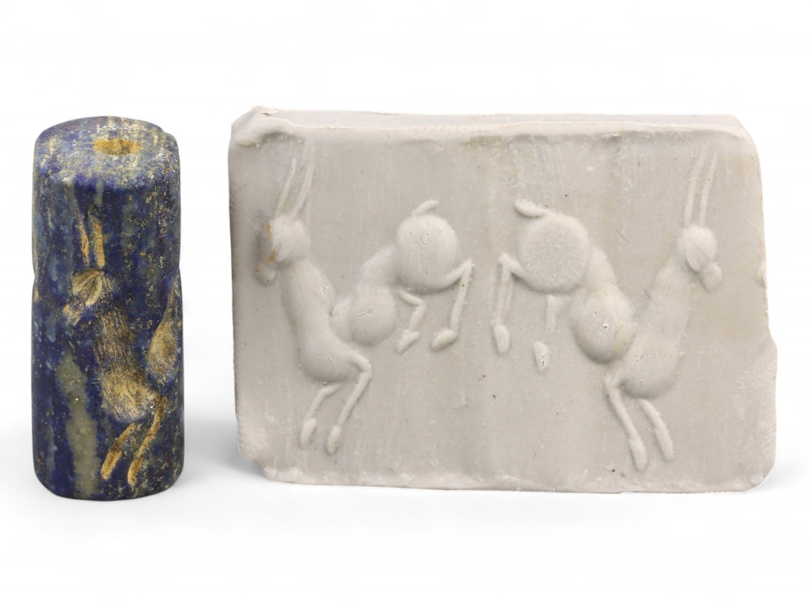 Ancient Akkadian Bounding Ibex Pair Cylinder Lapis Lazuli Seal, c. 2350-2150 BCE, 8.3g: This magnificent cylinder seal, hewn from lustrous lapis lazuli, hails from the height of the Akkadian Empire (c. 2350-2150 BCE) and showcases a kinetic composition of two ibexes caught mid-leap. With