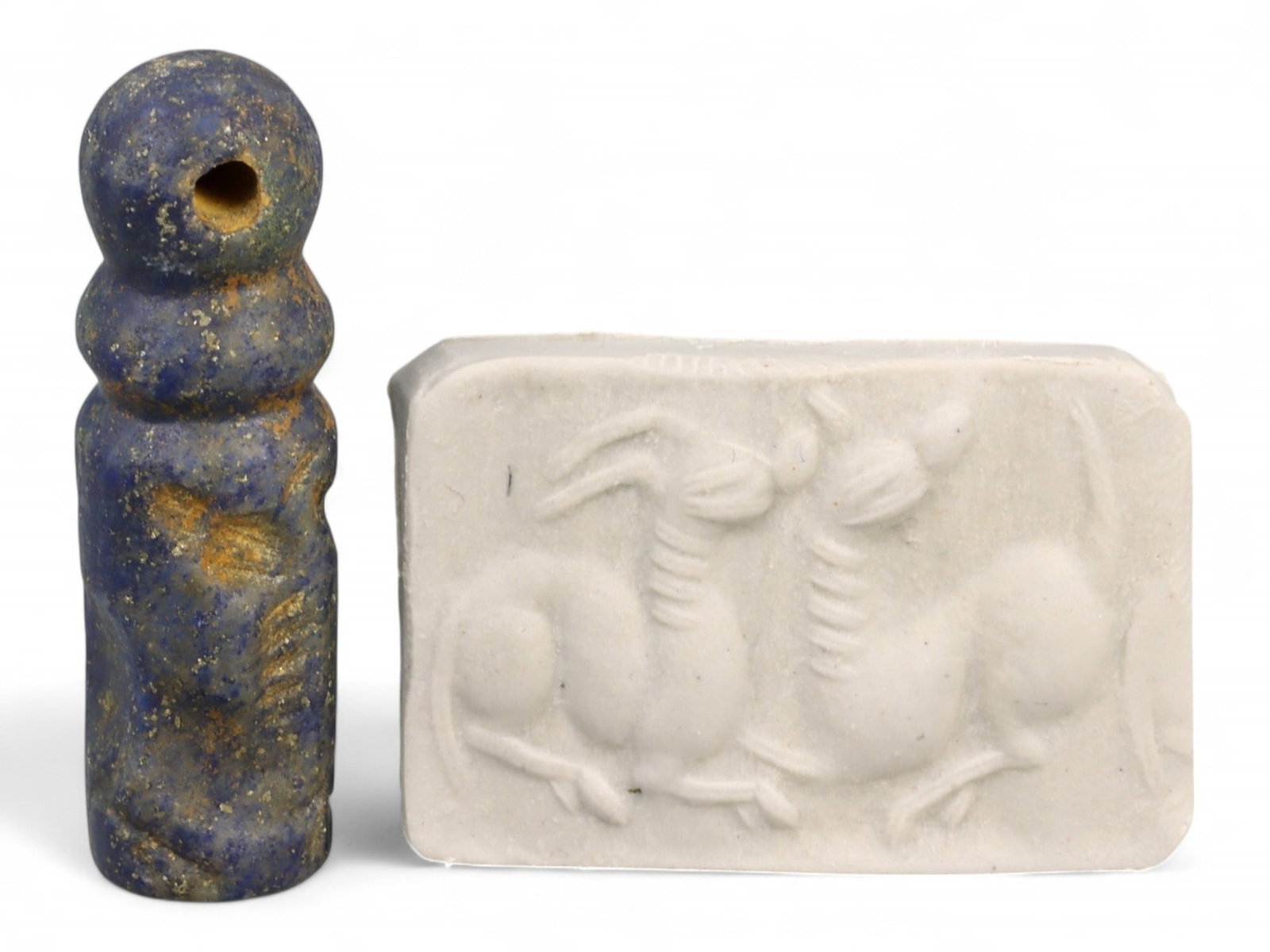 Ancient Akkadian Entwined Goat Pair Cylinder Lapis Lazuli Seal, c. 2350-2150 BCE, 6.2g: This remarkable Akkadian cylinder seal, carved from dense lapis lazuli, dates to c. 2350-2150 BCE and depicts an unusual mirrored composition of two horned goats or ibexes with interlocking necks and 