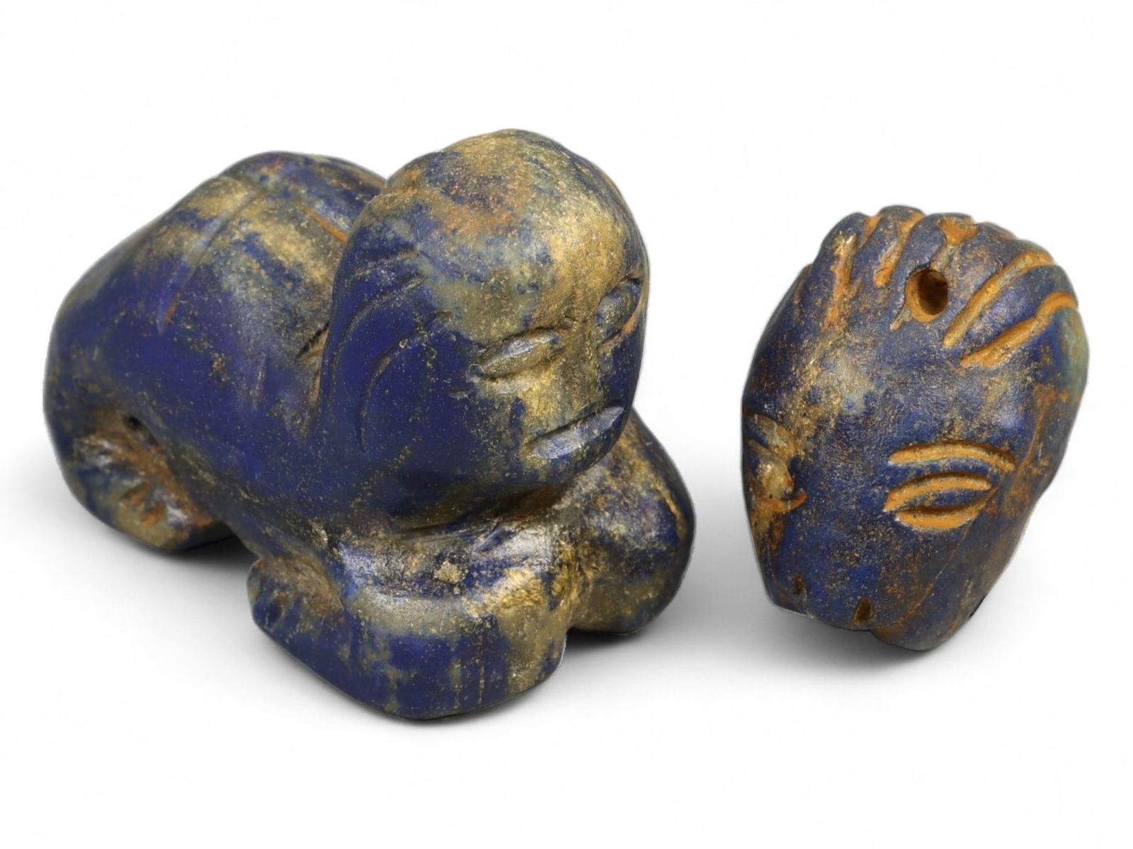 Ancient Bactrian Lapis Lazuli Reclining Sphinx and Human Head Amulets, 2pcs, 61.9g: This powerful duo of carved lapis lazuli figures-one a reclining sphinx, the other a stylized human head-originates from ancient Bactria, a crossroads of early civilization in Central Asia during the