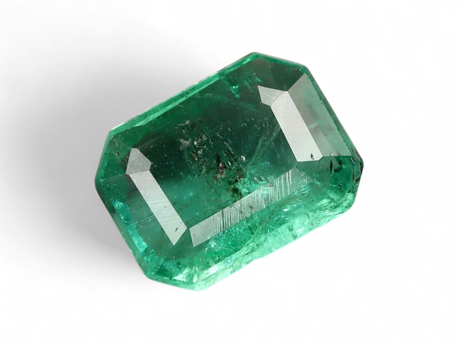 0.65 Carats Vivid Green Emerald - Natural Zambian Stone: This striking emerald displays a lively and saturated green, characteristic of Zambia's most coveted production. The stone's vivid hue is complemented by a fine balance of transparency and natural inc