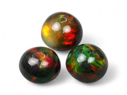 8.54 Carats Black Smoked Welo Opal Cabochon Trio - Natural Ethiopian Stones: This exceptional trio of black smoked Welo opals radiates a kaleidoscope of color, with vivid flashes of electric green, fiery red, golden yellow, and hints of violet playing across their domed caboch