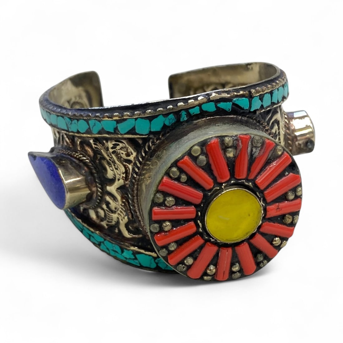Vintage Himalayan Tribal Turquoise Coral Lapis Sunburst Silver Cuff Bracelet, mid-20th Century, 175g: This vibrant vintage Himalayan cuff bracelet, likely from Nepal or Tibet in the mid-20th century, bursts with color and symbolism. At its center, a large circular sunburst motif radiates red coral inl