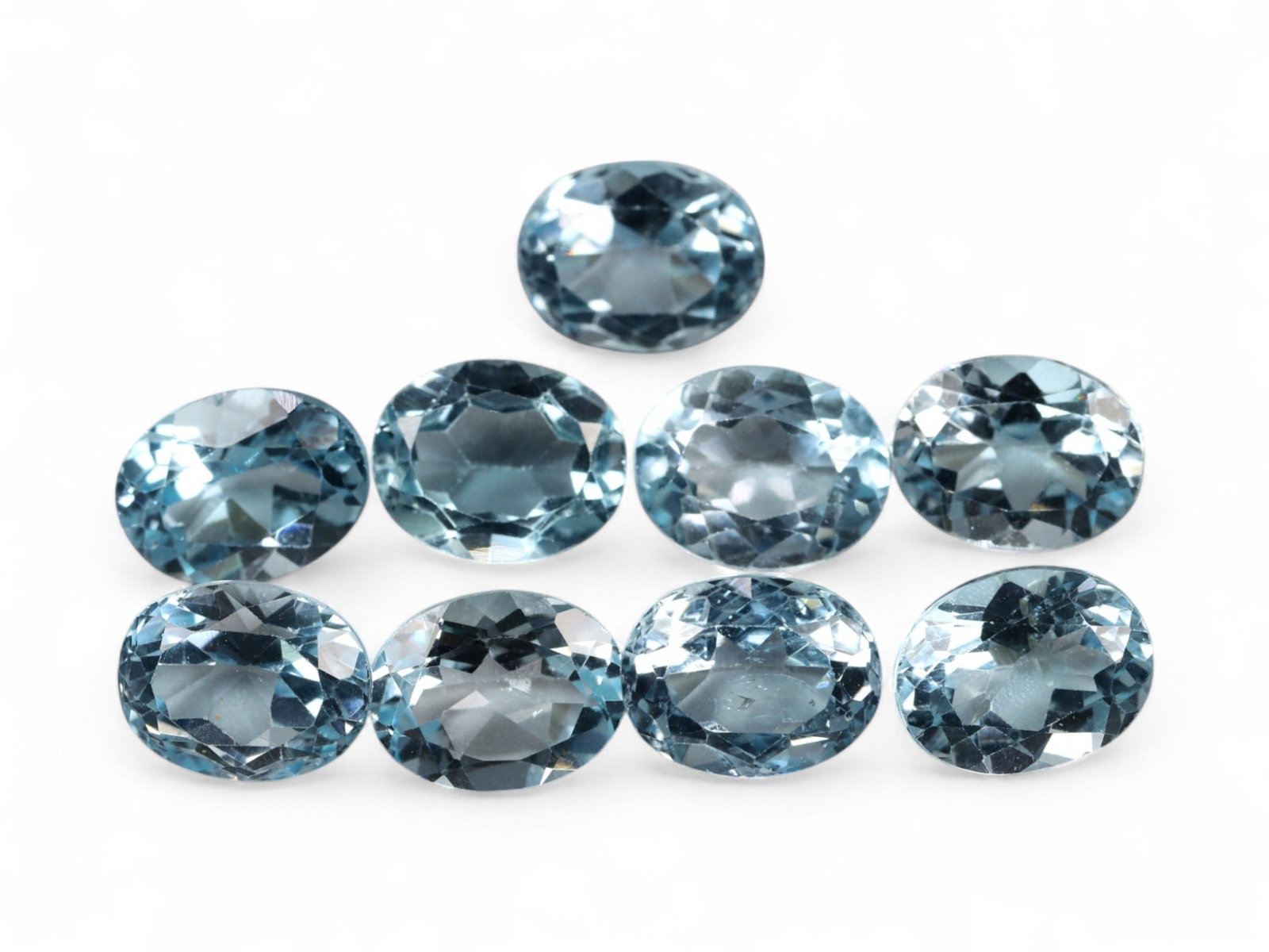 22.13 Carats Icy Blue Topaz Oval Lot - Natural Brazilian Stones: This sparkling selection of blue topaz gems glows with an icy, crystalline brilliance. Each stone exhibits a soft, sky-meets-aquamarine hue that evokes calm clarity, enhanced by precise oval faceting 