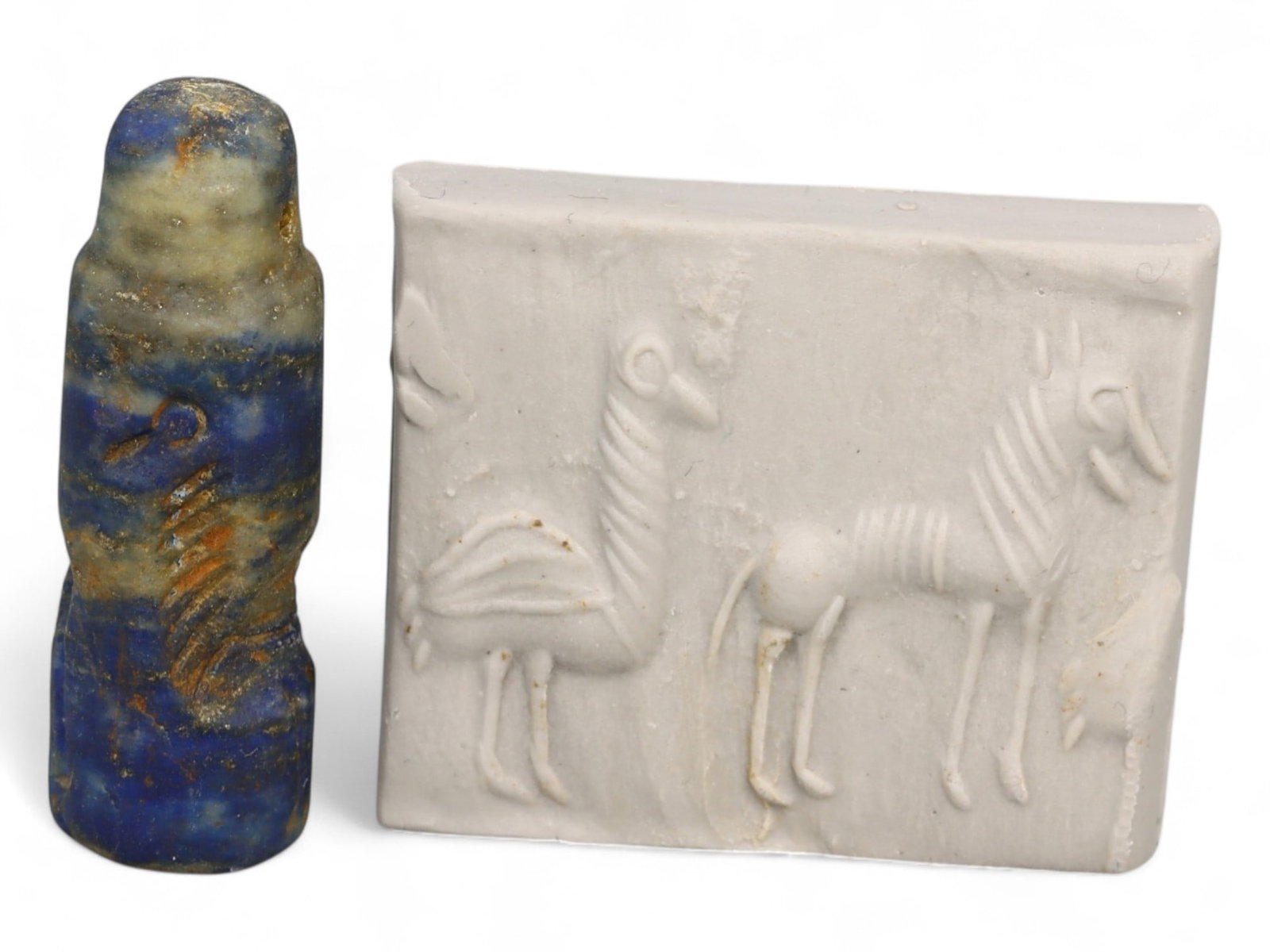 Ancient Akkadian Twin Animal High-Relief Lapis Lazuli Cylinder Seal, c. 2350-2150 BCE, 6.9g: This striking Akkadian cylinder seal, carved from richly colored lapis lazuli, measures 3 x 1 cm and weighs 6.9 grams. The high-relief design features two elegant animals - likely stylized goats or ga