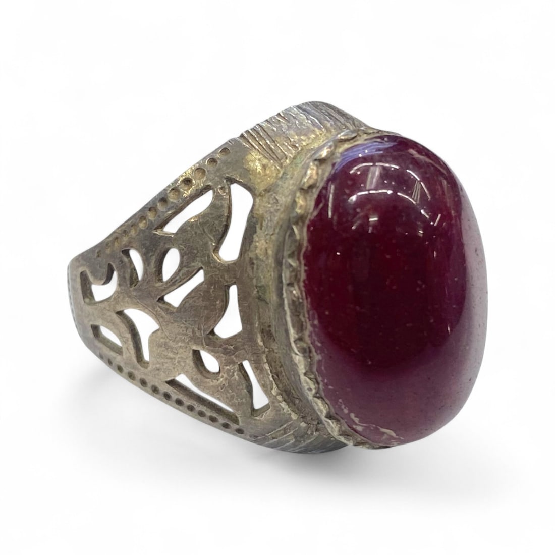 Antique Ottoman Floral Openwork Silver Ring with Garnet Cabochon, c. Early 20th Century, 7g: This antique silver ring, likely crafted during the early 20th century in the Ottoman or Levantine region, presents a vibrant garnet-colored cabochon within a delicately pierced floral band. The desig