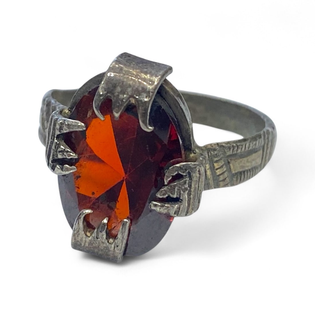 Antique Claw-Prong Silver Ring with Faceted Garnet Glass, c. Mid-20th Century, 4g: This striking antique silver ring presents a fiery faceted red-orange gemstone-likely garnet glass-held securely in a dramatic claw-prong setting. Crafted in the mid-20th century, this piece combines 