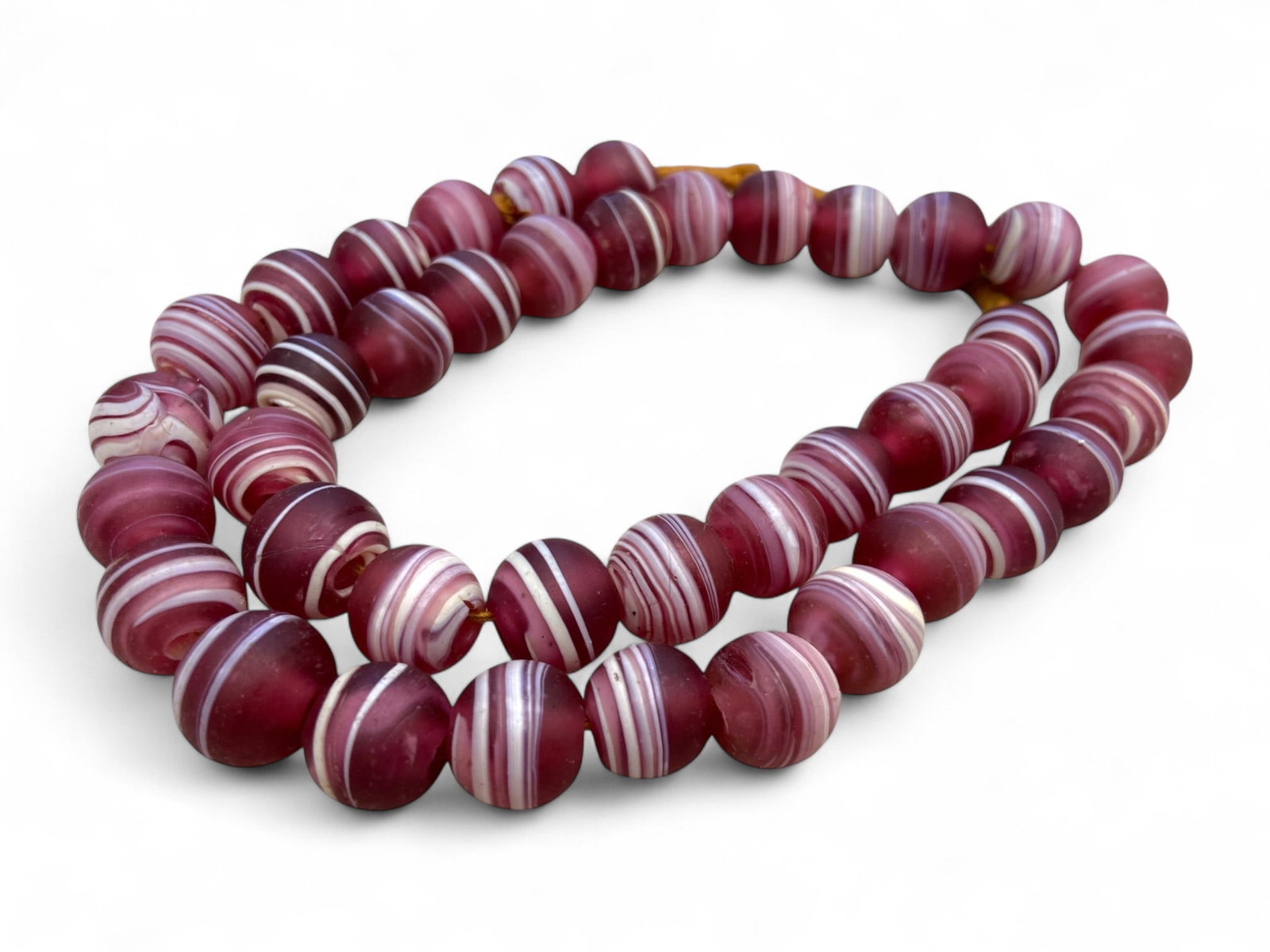 Vintage Venetian Candystripe Glass Trade Bead Strand, Striped Ornamentation, Early 20th Century 160g: This vibrant strand of Venetian candystripe trade beads, crafted in the early 20th century, embodies the rich artistic legacy of Murano glassmakers and their global cultural influence. Made using a dr