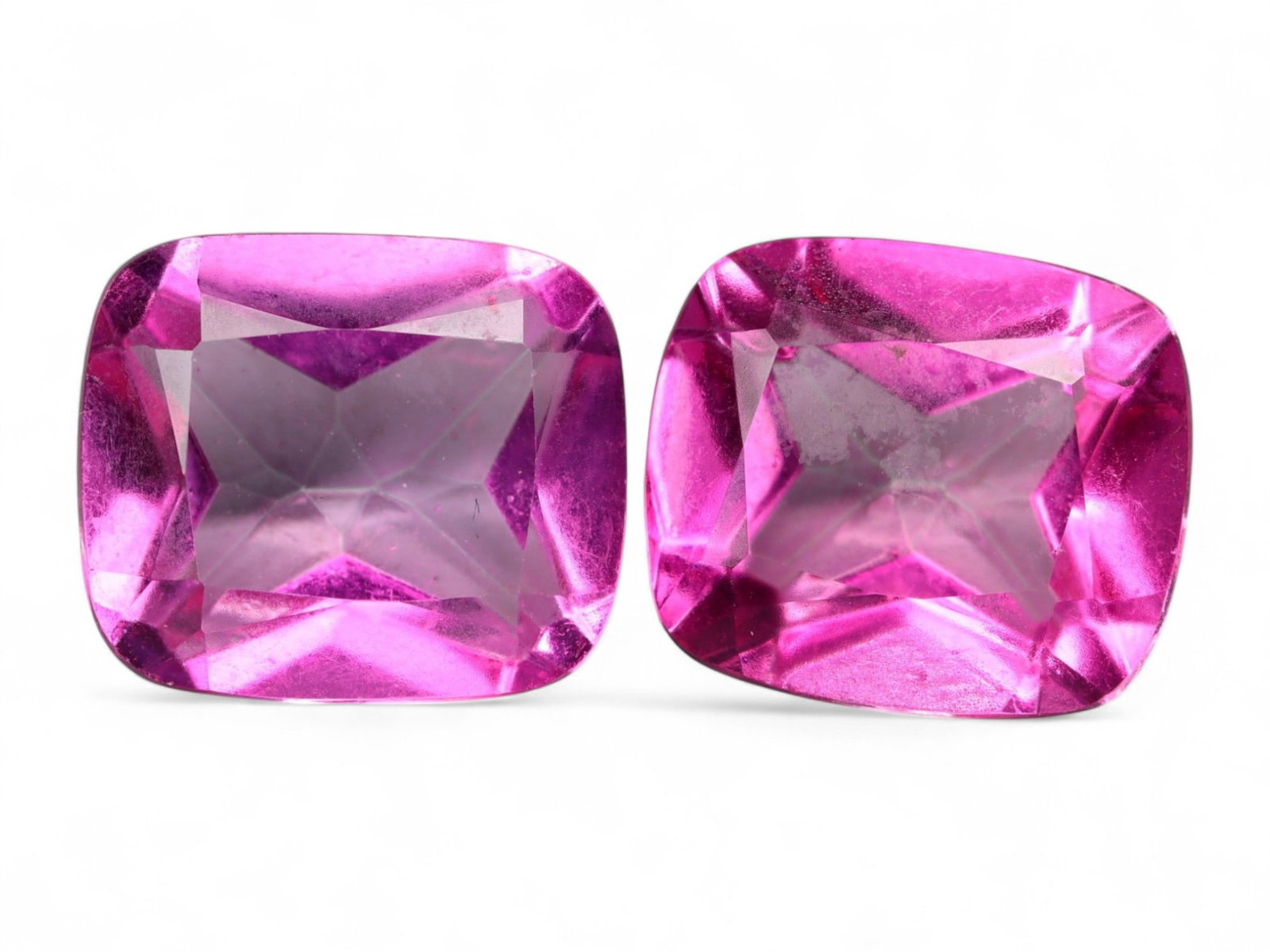 20.60 Carats Vivid Pink Topaz Cushion Pair - Color-Enhanced Brazilian Stones: This dazzling pair of cushion-cut topaz gems showcases an intense, electric pink hue with striking vibrancy and mirror-like brilliance. The stones are beautifully proportioned with symmetrical facetin