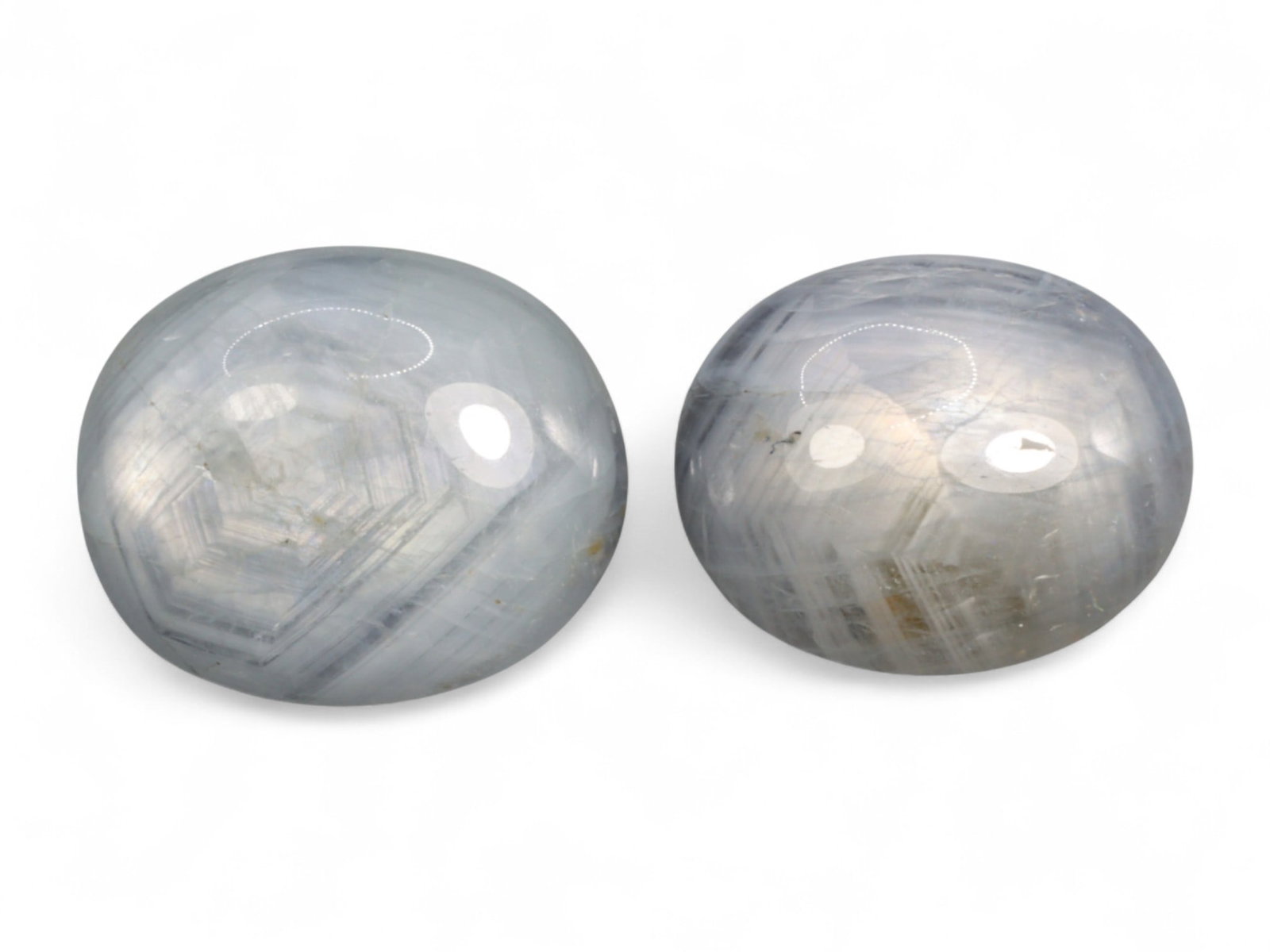 17.84 Carats Grey Star Sapphire Pair - Natural Burmese Stones: This captivating duo of grey star sapphires exhibits the subtle magnetism of celestial shimmer across cool, moody tones. Each cabochon reveals a soft, silvery asterism under direct light, gracefully s