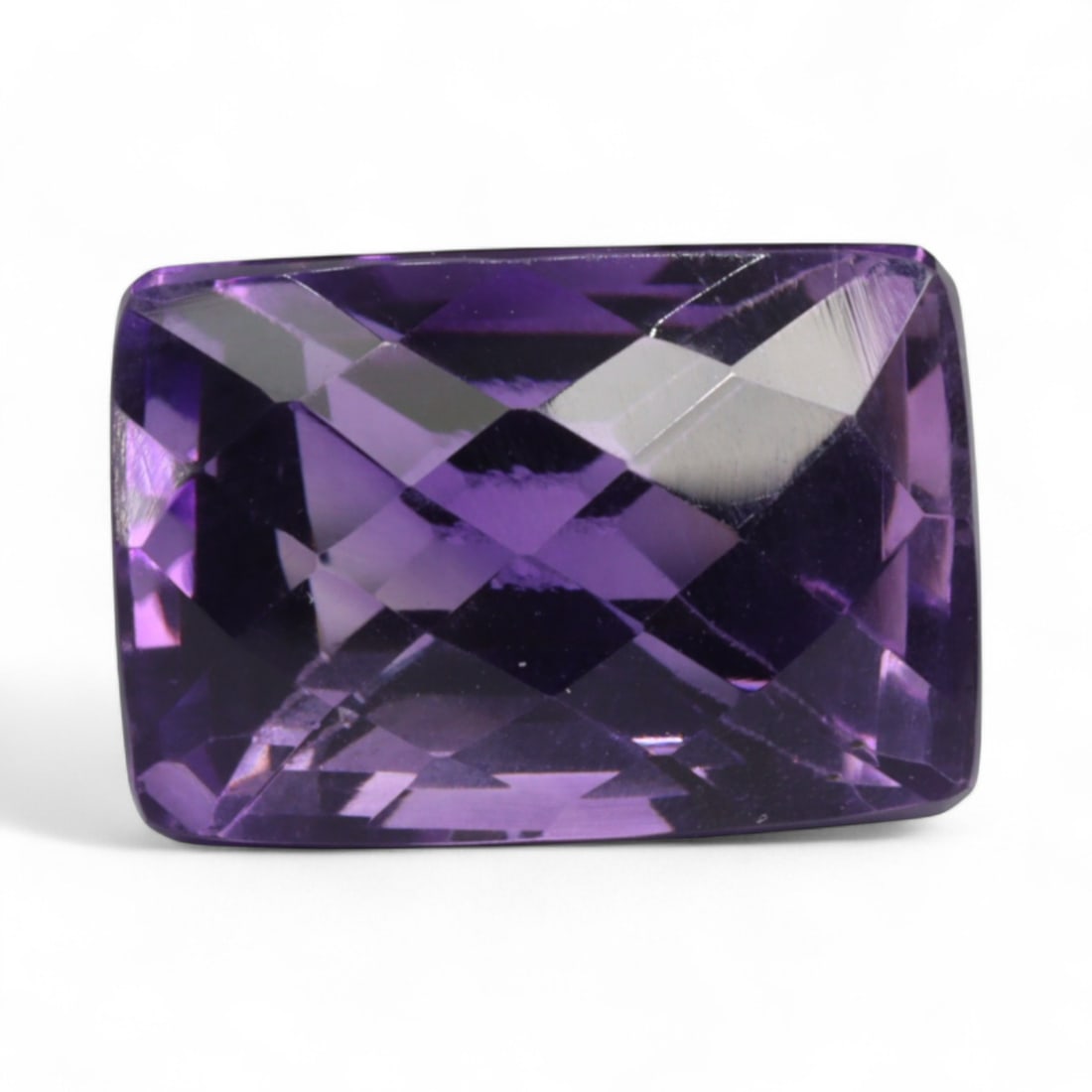19.08 Carats Royal Purple Amethyst Cushion - Natural Brazilian Stone: This commanding cushion-cut amethyst presents a deep royal purple tone with well-defined brilliance that shimmers across its faceted surface. The rectangular silhouette is enhanced by crisp step facet