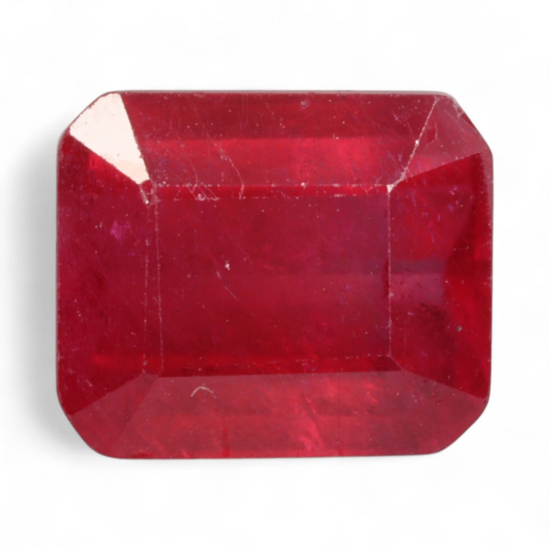 6.15 Carats Intense Red Ruby - Emerald Cut from Natural Mozambique: This substantial ruby showcases an intense red hue enhanced by its clean emerald cut, delivering both color saturation and architectural elegance. The octagonal profile creates broad, mirror-like face