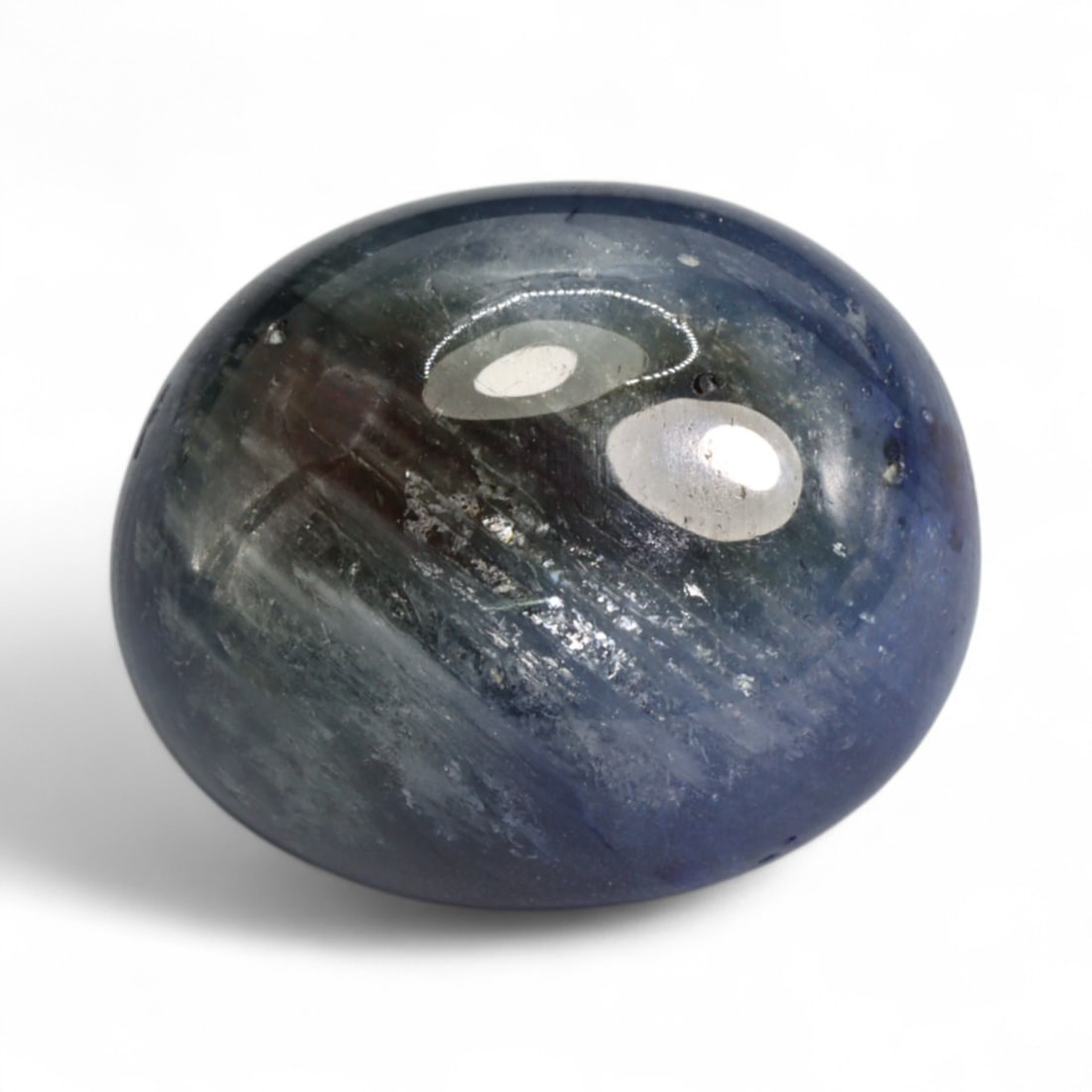 25.42 Carats Royal Blue Sapphire Cabochon - Natural Ceylon Origin: This commanding sapphire cabochon showcases a bold royal blue hue with swirling silvery inclusions that shimmer beneath the surface, giving it both color intensity and visual intrigue. Its polished do