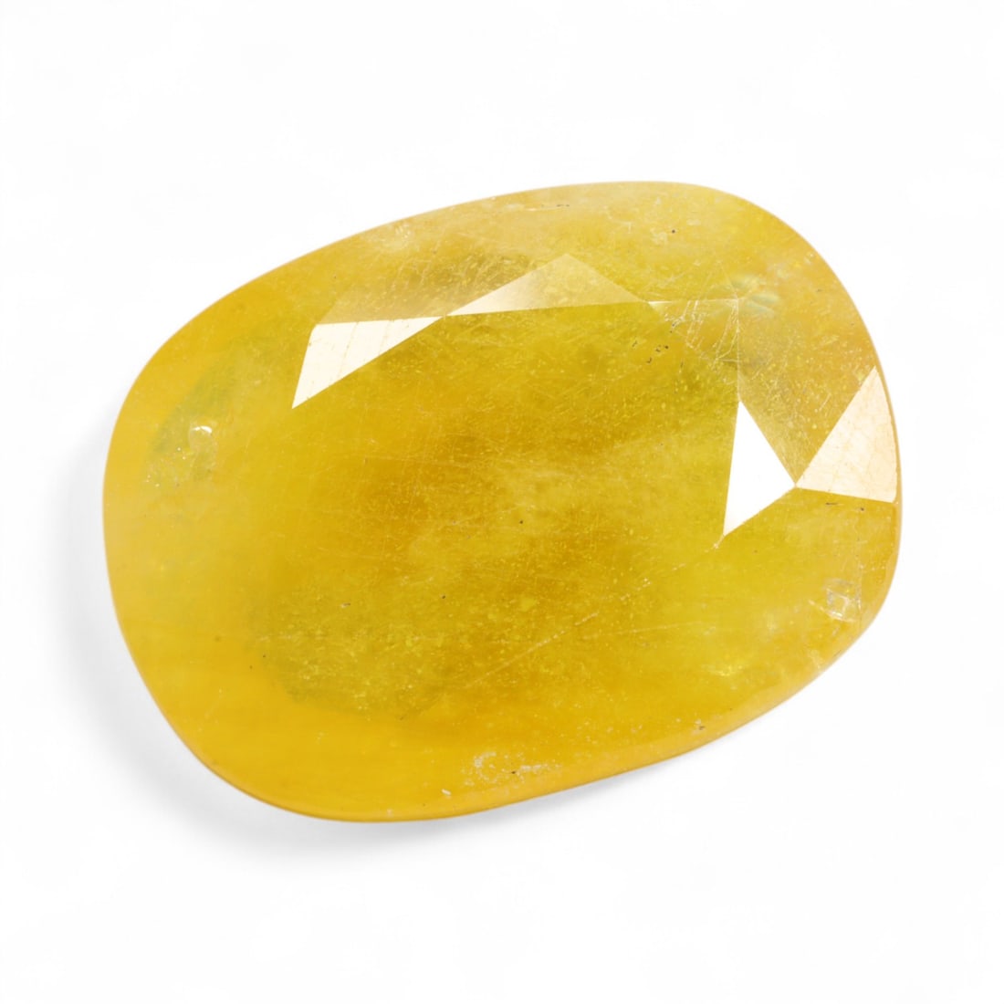 28.09 Carats Earthy Golden Yellow Sapphire - Natural African Stone: This substantial yellow sapphire displays a warm, earthy golden tone with a softly diffused inner glow. Its surface reveals natural inclusions and internal textures that lend a raw, organic character,