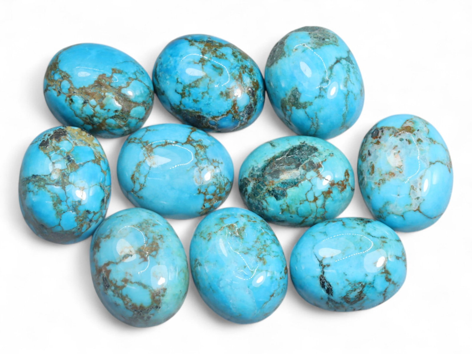 30.02 Carats Sky Blue Turquoise Cabochon Lot - Natural American Stones: This well-matched lot of turquoise cabochons glows with vivid sky blue hues accented by earthy brown and gray veining. The smooth oval domes are polished to a bright finish, showcasing the natural mat