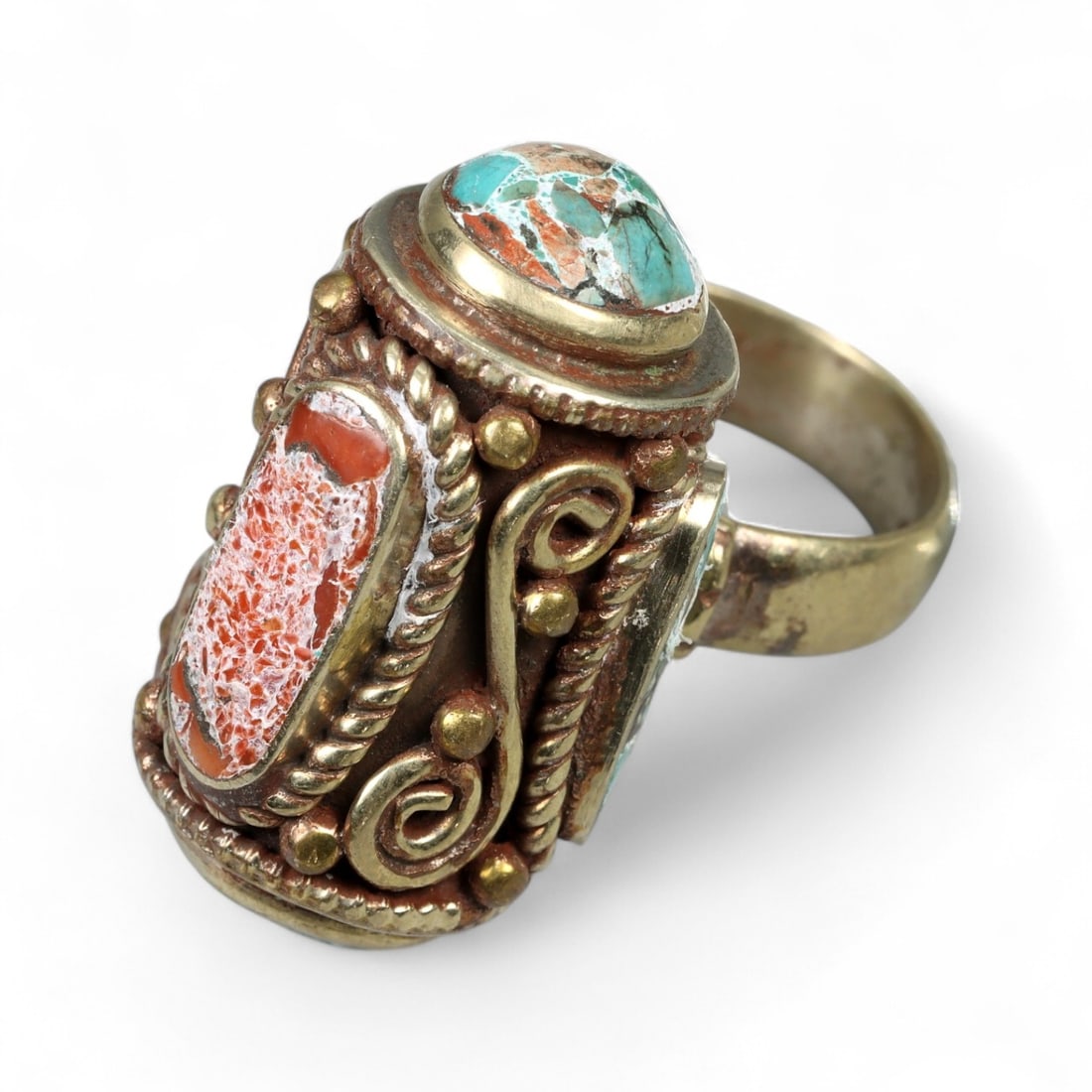 Antique Himalayan Pillar Ring with Coral and Turquoise Inlay, c. Mid-20th Century, 19g: A masterwork of Himalayan ritual design, this antique pillar-style ring is both sculptural and spiritual in its form. Rising vertically above the finger, its elongated cylindrical bezel is framed with
