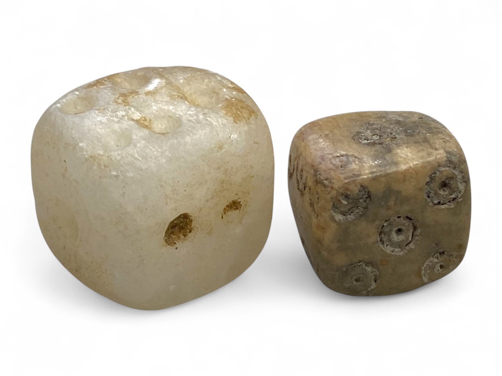 Ancient Roman Bone and Calcite Gaming Dice Pair, c. 1st-5th Century CE (9g): This rare matched set of two ancient dice - one carved from creamy calcite and the other from well-aged bone - offers a tangible link to the leisure and rituals of daily life in the Roman world. Datin