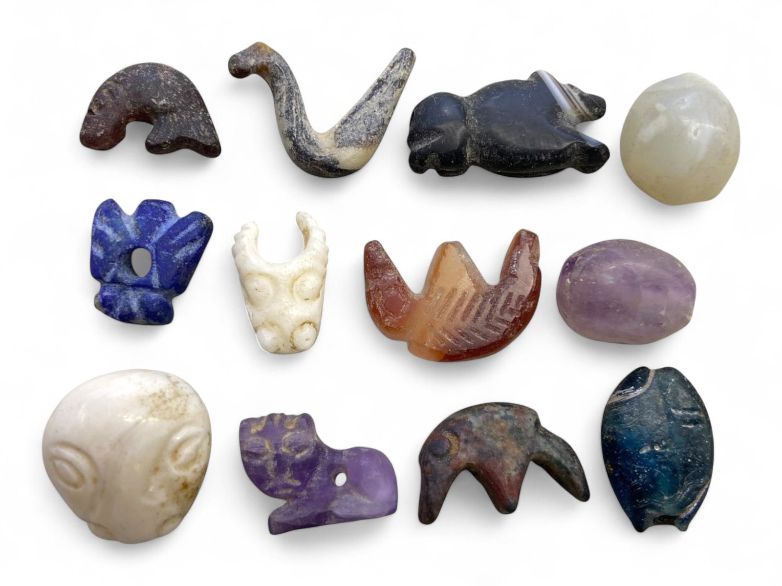 Ancient Indus-Bactrian Zoomorphic and Anthropomorphic Amulet Collection, 3rd-2nd Millennium BCE, 25g: This exquisite ensemble of twelve miniature carved amulets and beads, dating from the 3rd to 2nd millennium BCE, captures the sacred artistry and symbolic language of the Indus Valley, Bactrian, and E
