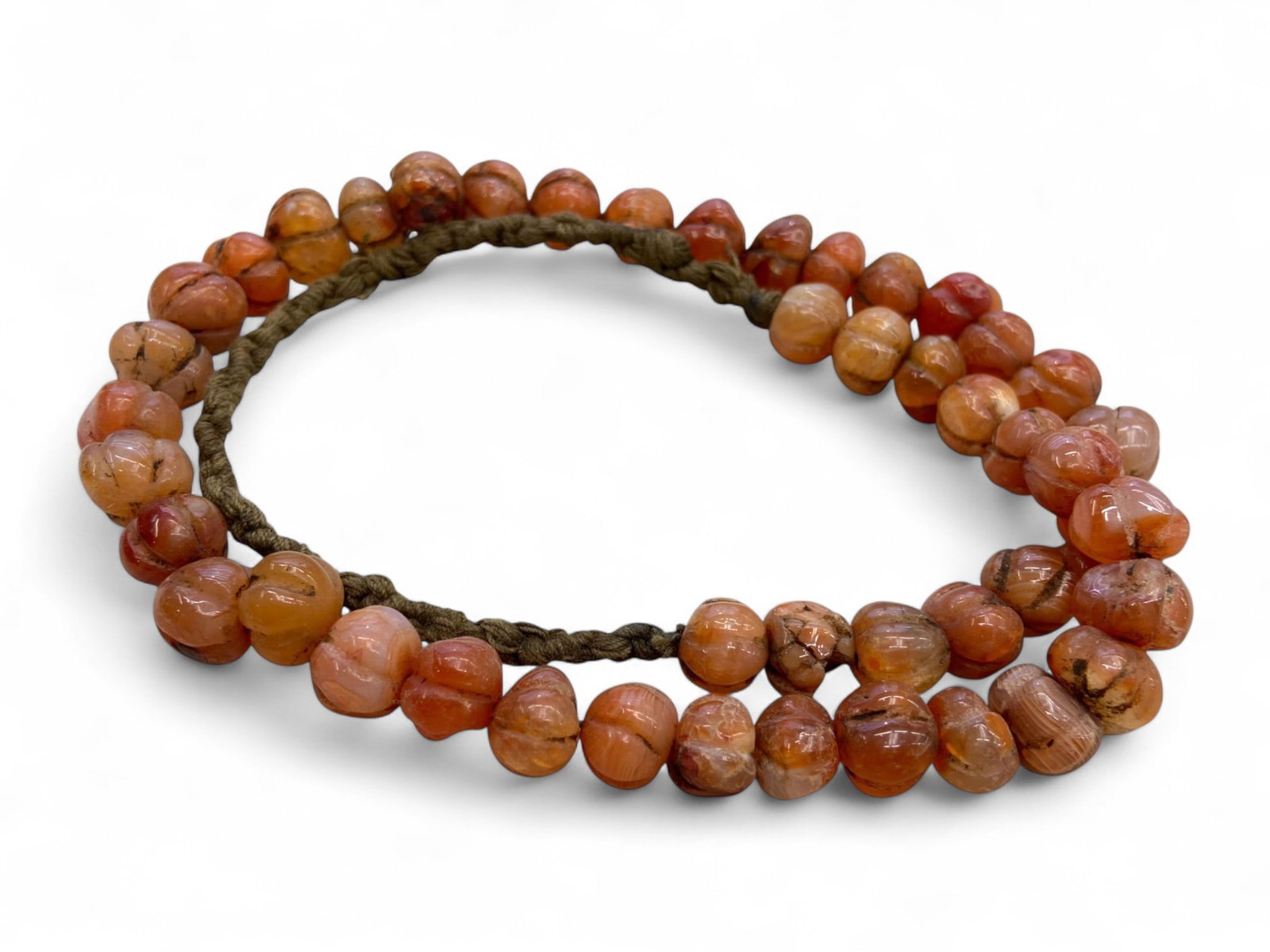 Ancient Medieval Islamic Carnelian Melon-Cut Beads Strand, c. 10th-13th Century CE, 88g: This luminous strand of carved carnelian beads exemplifies the refined lapidary traditions of the medieval Islamic world between the 10th and 13th centuries CE. Carefully shaped into melon-like forms,