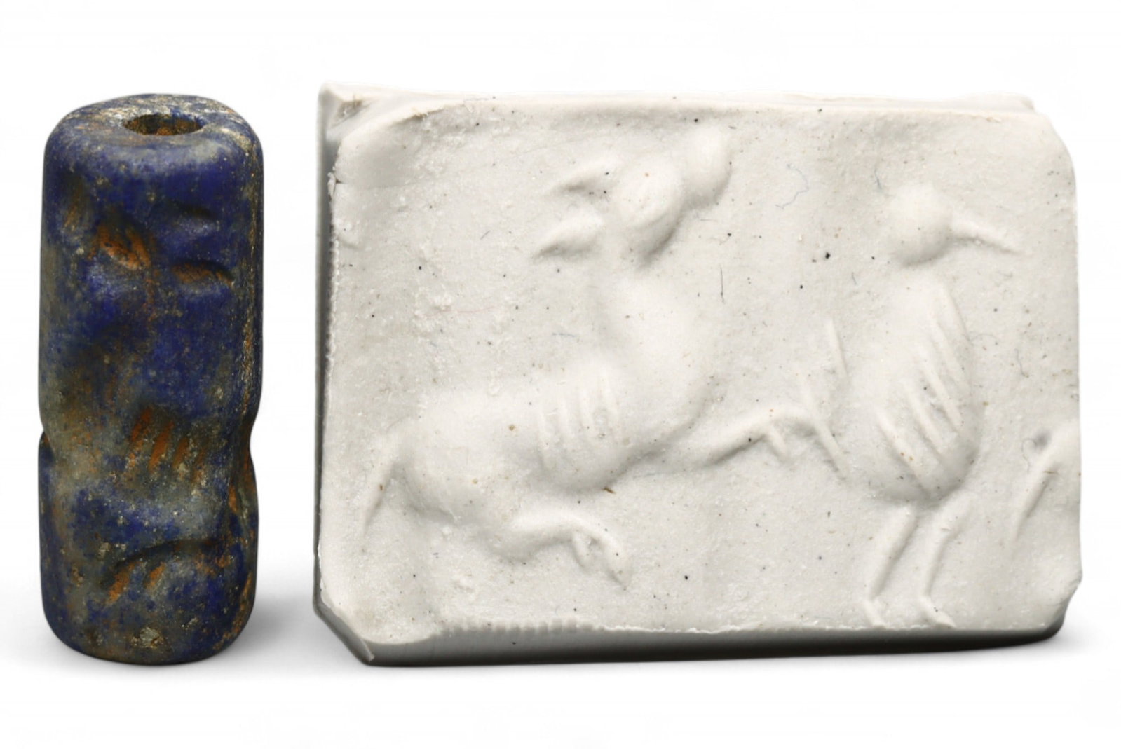 Ancient Akkadian Leaping Ibex and Bird High-Relief Lapis Lazuli Cylinder Seal, c. 2350-2150 BCE,: This finely carved Akkadian cylinder seal, measuring 2.3 x 1 cm and weighing 4.2 grams, is fashioned from rare lapis lazuli, one of the most valued gemstones of the ancient Near East. The high-relief 