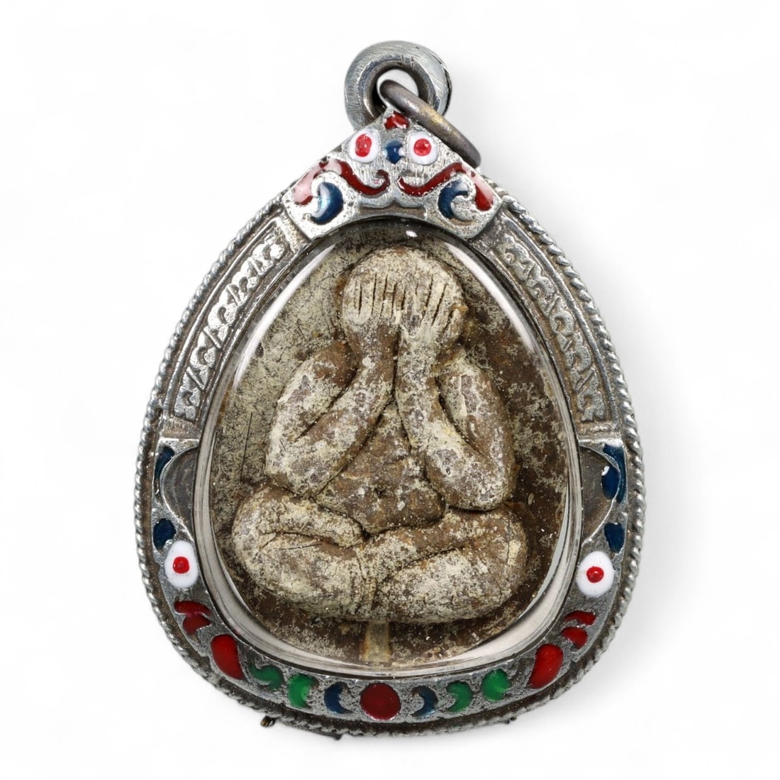 Vintage Thai Phra Pidta Protection Amulet in Enamel Teardrop Case, c. Mid-20th Century, 40g: This vintage Thai amulet features the powerful image of Phra Pidta, the "Closed Eyes Monk," portrayed seated in deep meditation with hands covering the face. A revered figure in Thai Buddhist iconogra
