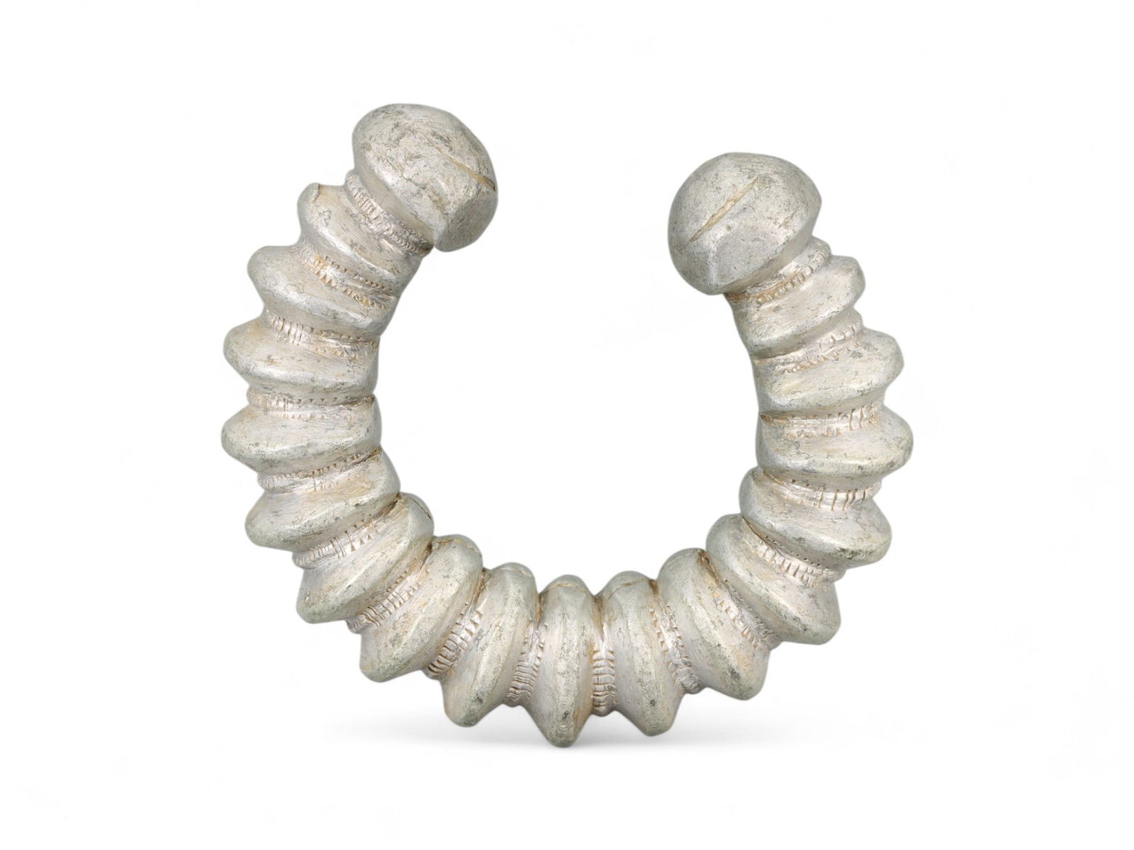 Antique West African Spiral Form Cast Aluminum Currency Bracelet, Early 20th Century, 8cm, 107g: This striking antique bracelet, cast in aluminum and designed in an exaggerated spiral form, represents the evolving tradition of currency adornment in early 20th-century West Africa. This piece stand
