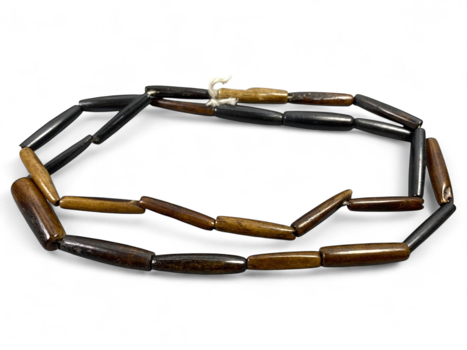 Vintage Tibetan Long Barrel Bone Bead Strand, Unstrung Prayer Supply, c. 20th Century, 21g: This vintage strand of elongated barrel-shaped Tibetan bone beads exemplifies the meditative artistry of Himalayan culture in the 20th century. Each bead, hand-shaped and gently polished, carries the